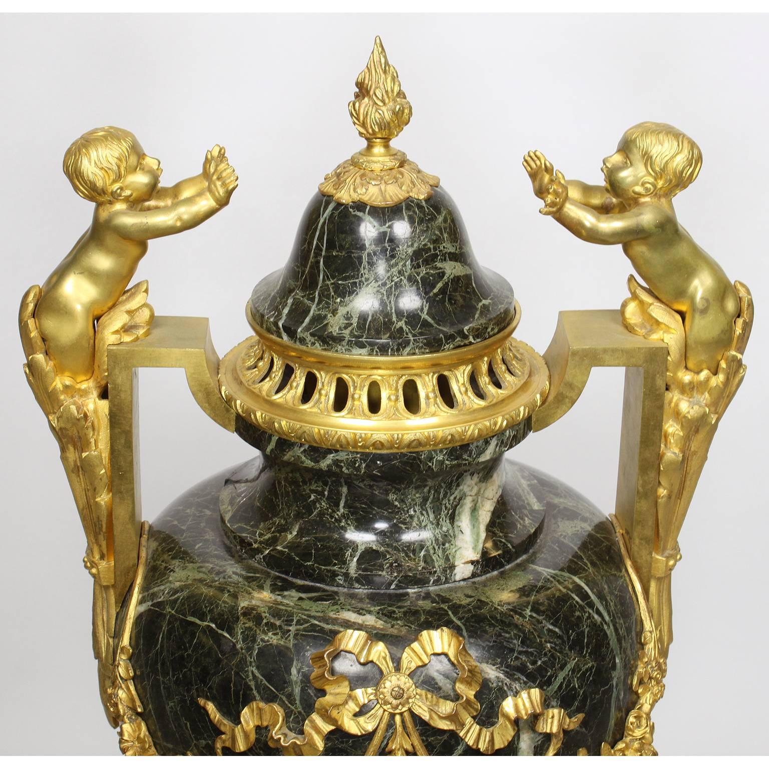 Paar Urnen aus Goldbronze und Marmor im Louis-XVI.-Stil des 19. und 20. Jahrhunderts mit Kindern (Vergoldet) im Angebot