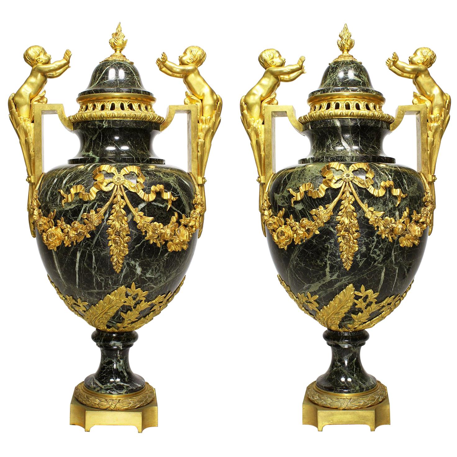 Paire d'urnes de style Louis XVI du 19e-20e siècle en bronze doré et marbre avec enfants
