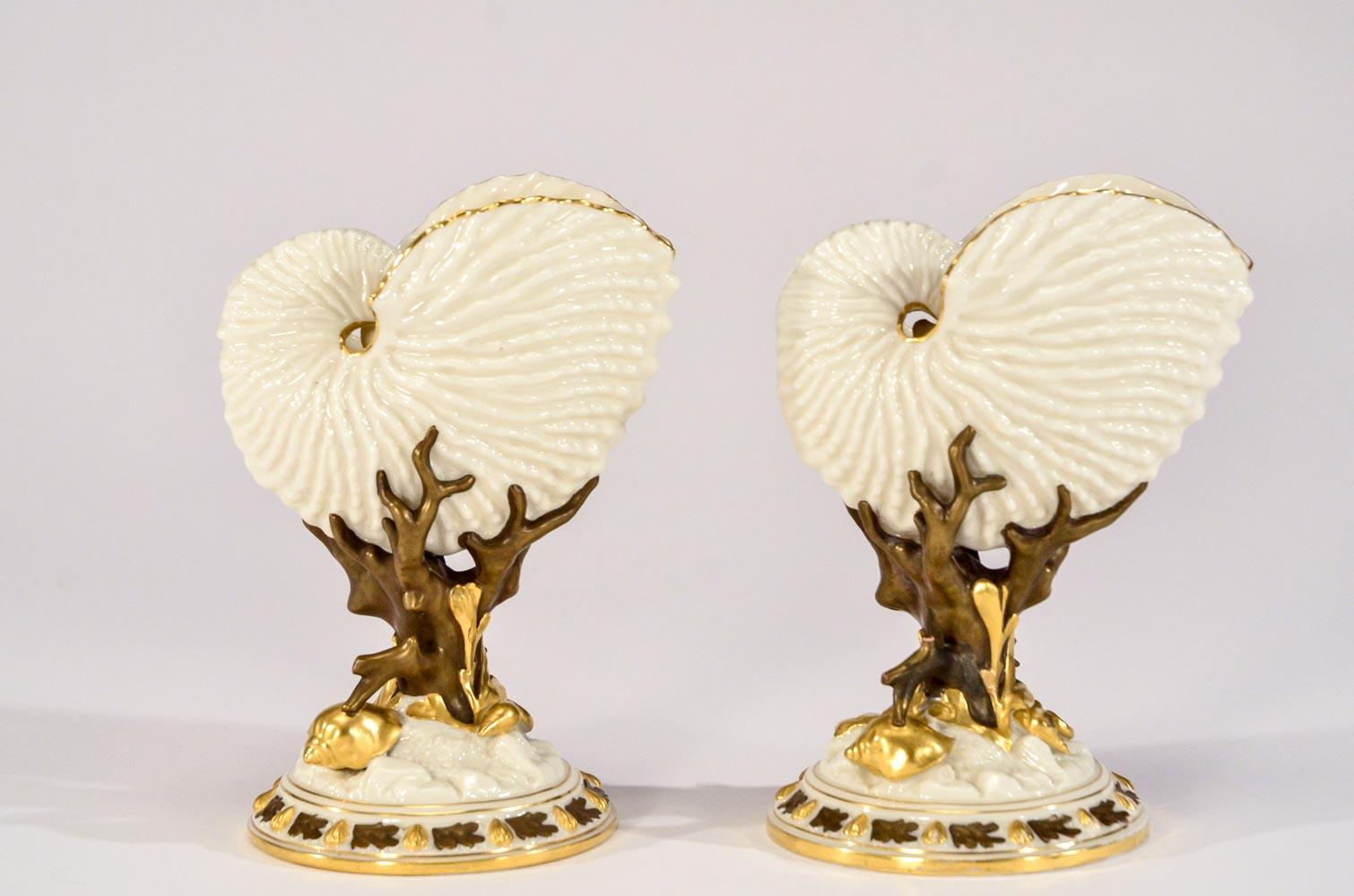 Ces rares exemples de vases à thème en porcelaine ivoire du Mouvement esthétique présentent une paire assortie de coquillages ouverts moulés de façon réaliste, nichés dans des branches de corail. Les parois translucides laissent passer la lumière