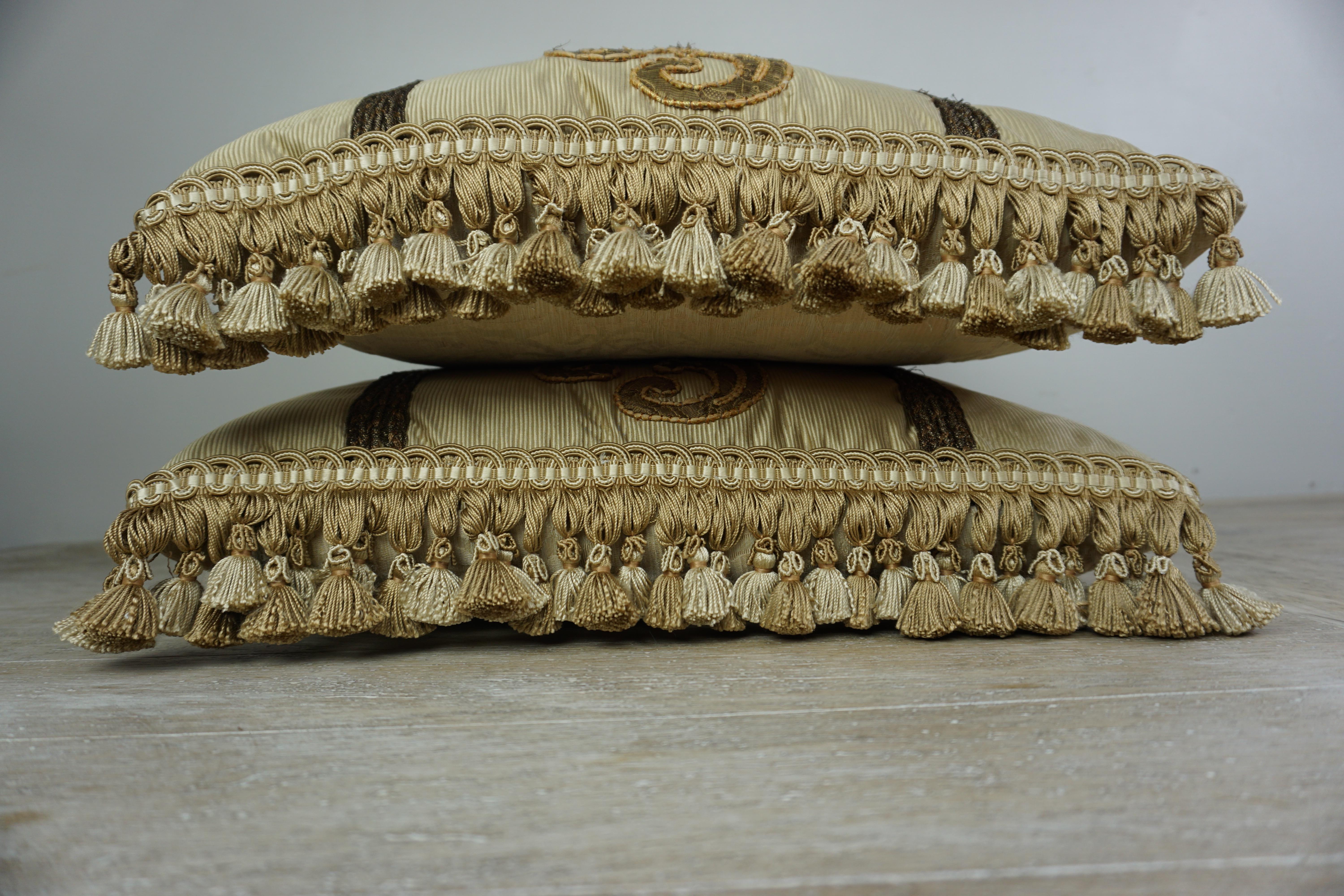 Pair of custom pillows designed by Melissa Levinson with 19th century metallic appliques on silk fronts. Silk damask backs and tassel trim at sides of pillows. Down inserts, sewn closed.