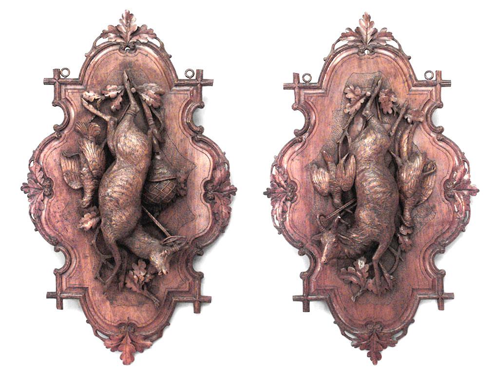 Pair of nineteenth century rustic walnut wall plaques depicting an assortment of game hanging against a shaped foliate trimmed background.