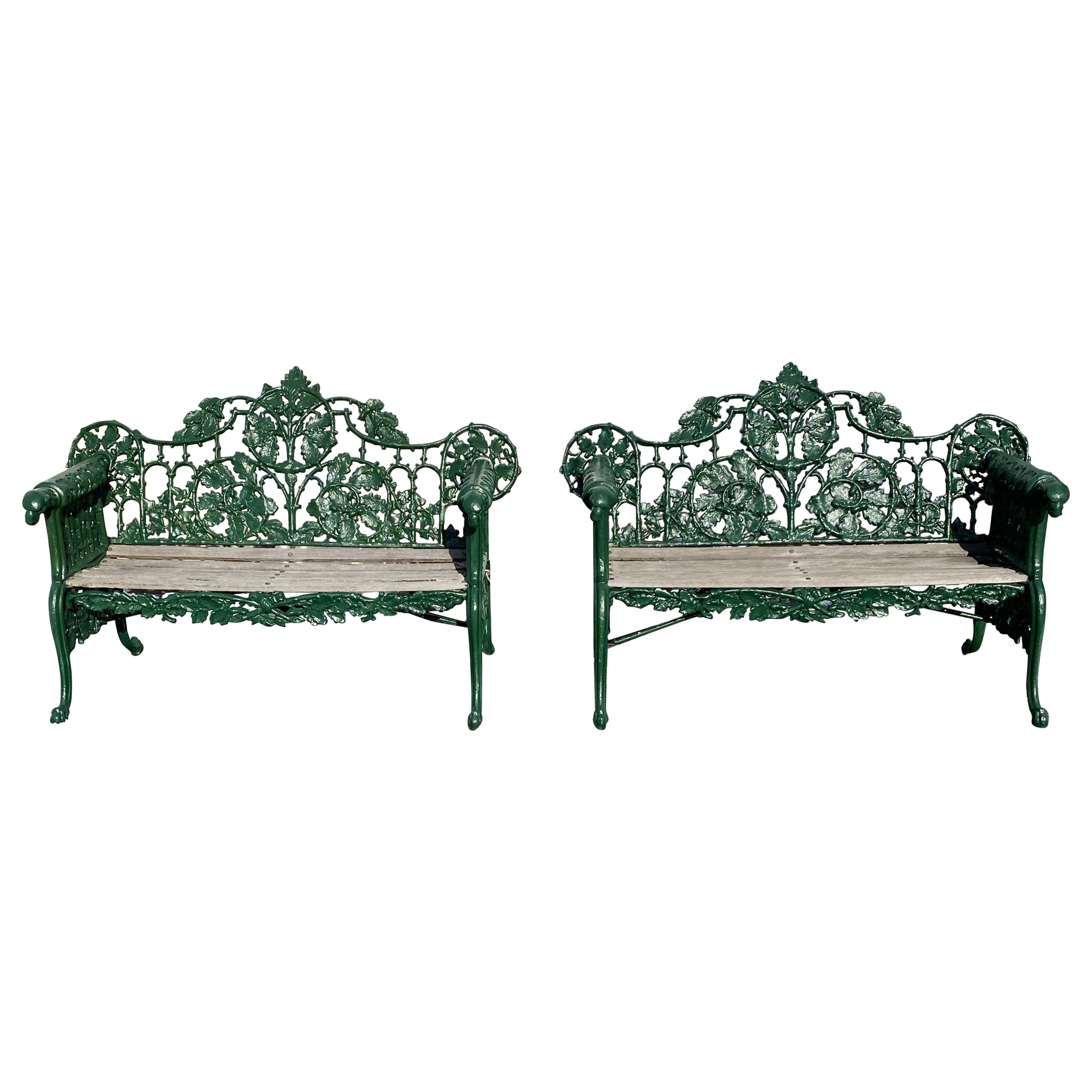 Pareja de bancos de hierro fundido y madera del s. XIX con motivos de hojas de roble y asas de cabeza de perro