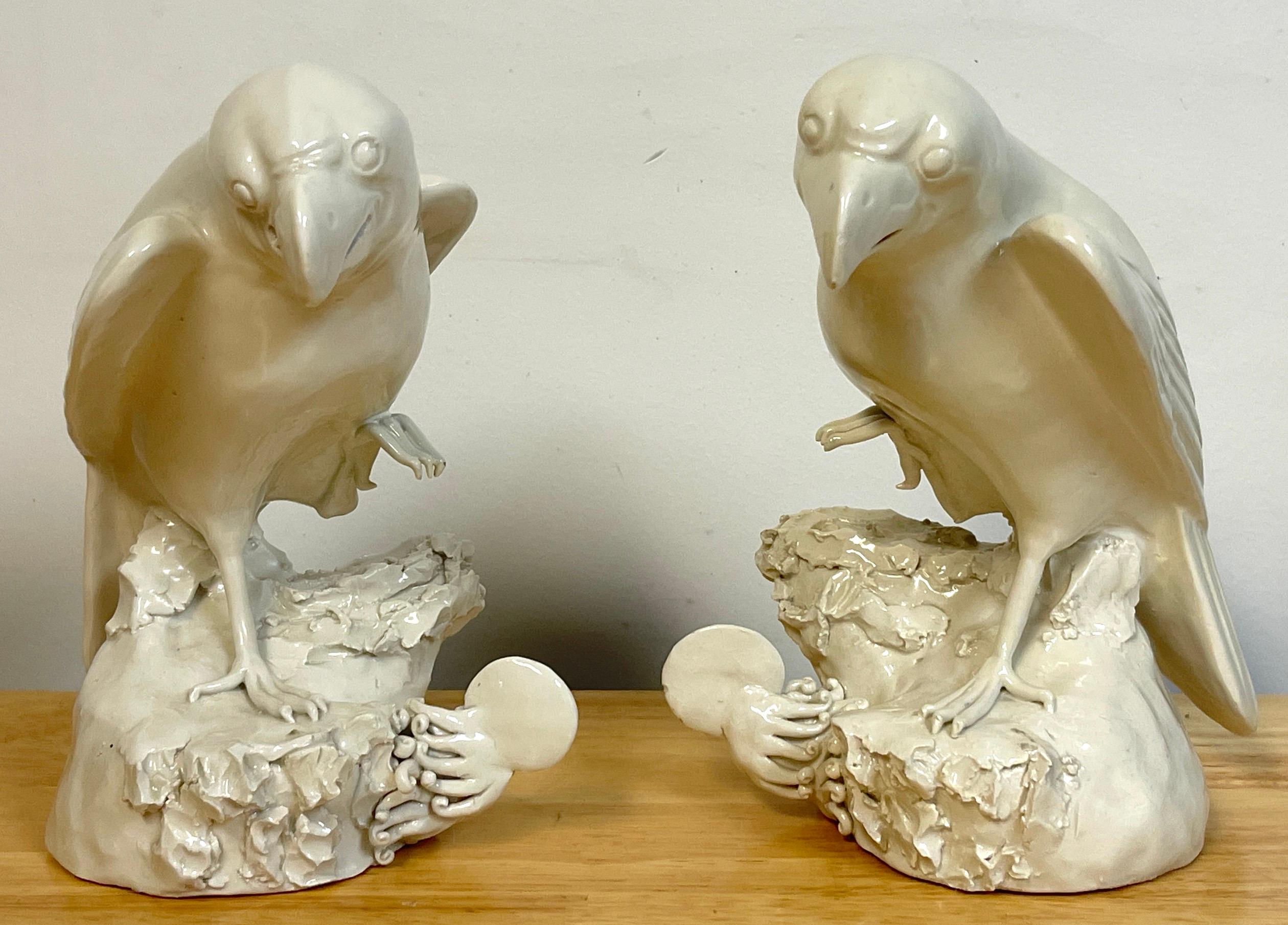 Pair of 19th C Chinese Blanc de Chine figures of parrots, each one standing on symbolistic naturalistic bases, standing with one leg raised, facing left and right. 
The base measures 4