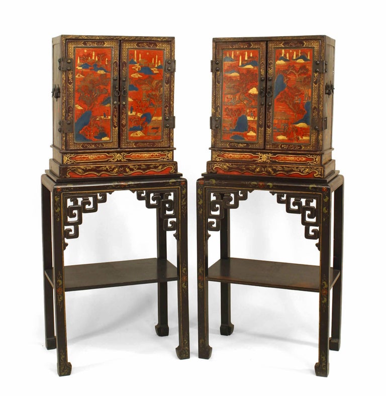 Pair of Asian Chinese (19th Century) decorated lacquered small 2 door cabinets with scenes and figures on rectangular stands with filigree corners and shelf (PRICED AS Pair).
