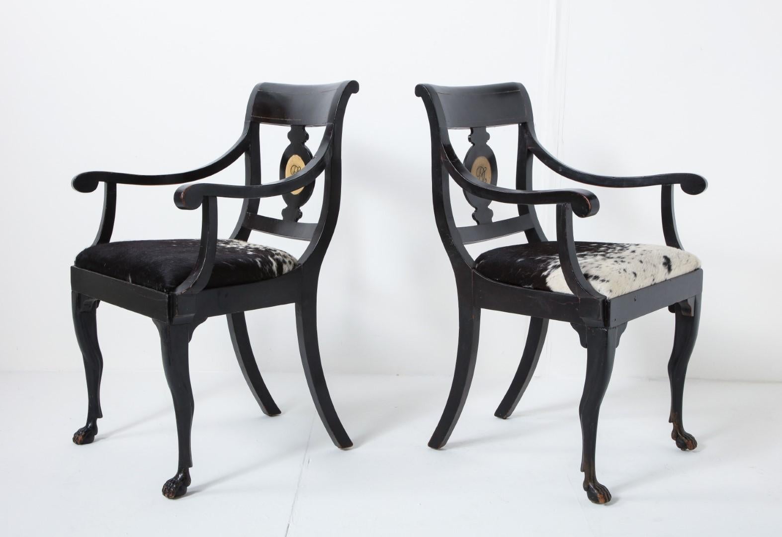 Ein Paar englische ebonisierte Regency-Sessel aus dem 19. Jahrhundert mit handgemaltem Monogramm. Sitze aus natürlichem Ponyfell in Schwarz und Weiß.

Maße: Armhöhe 25