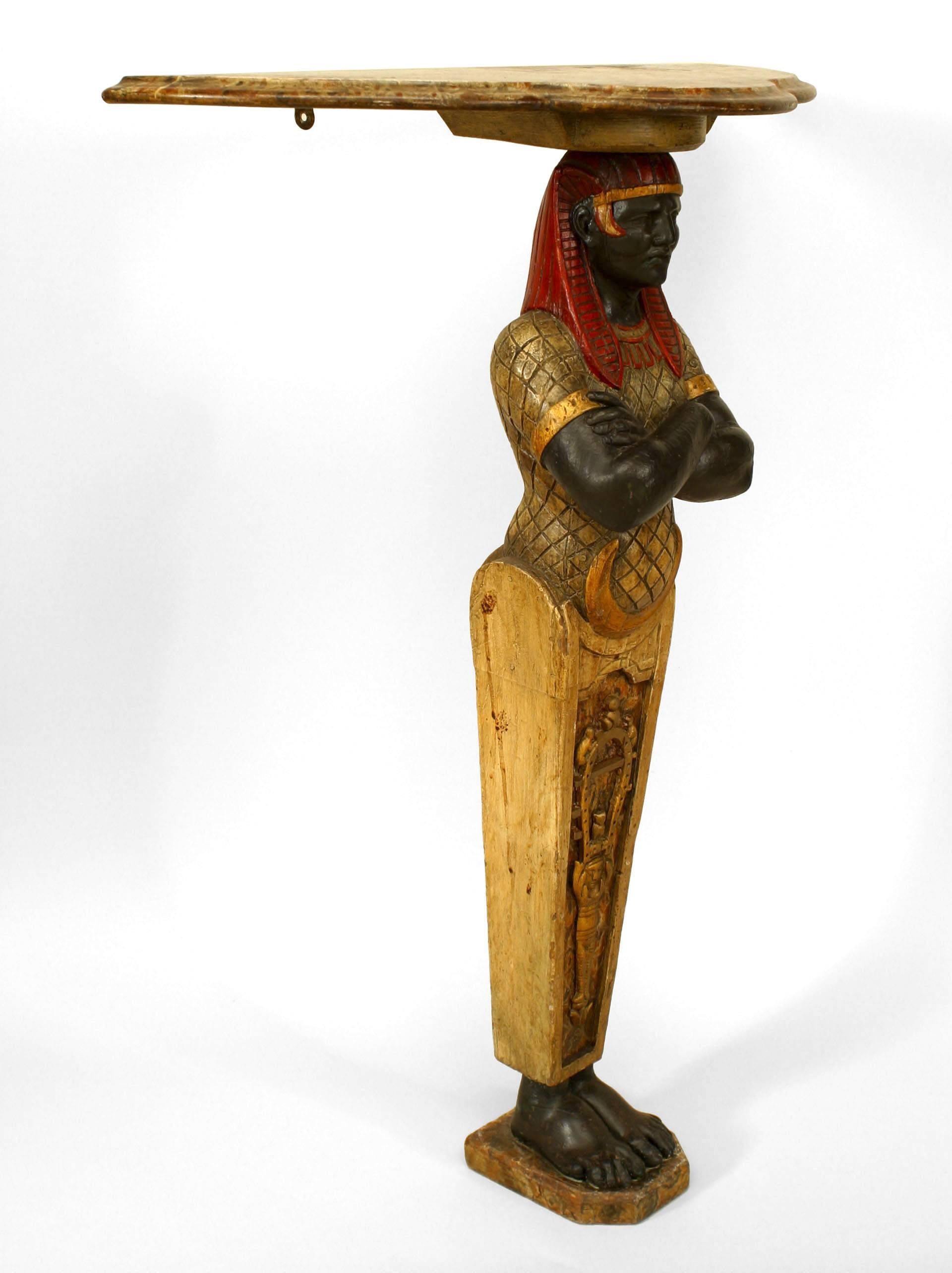 Paire de consoles de style égyptien (époque victorienne anglaise) peintes et décorées, avec base à figures égyptiennes et plateau en faux marbre façonné
