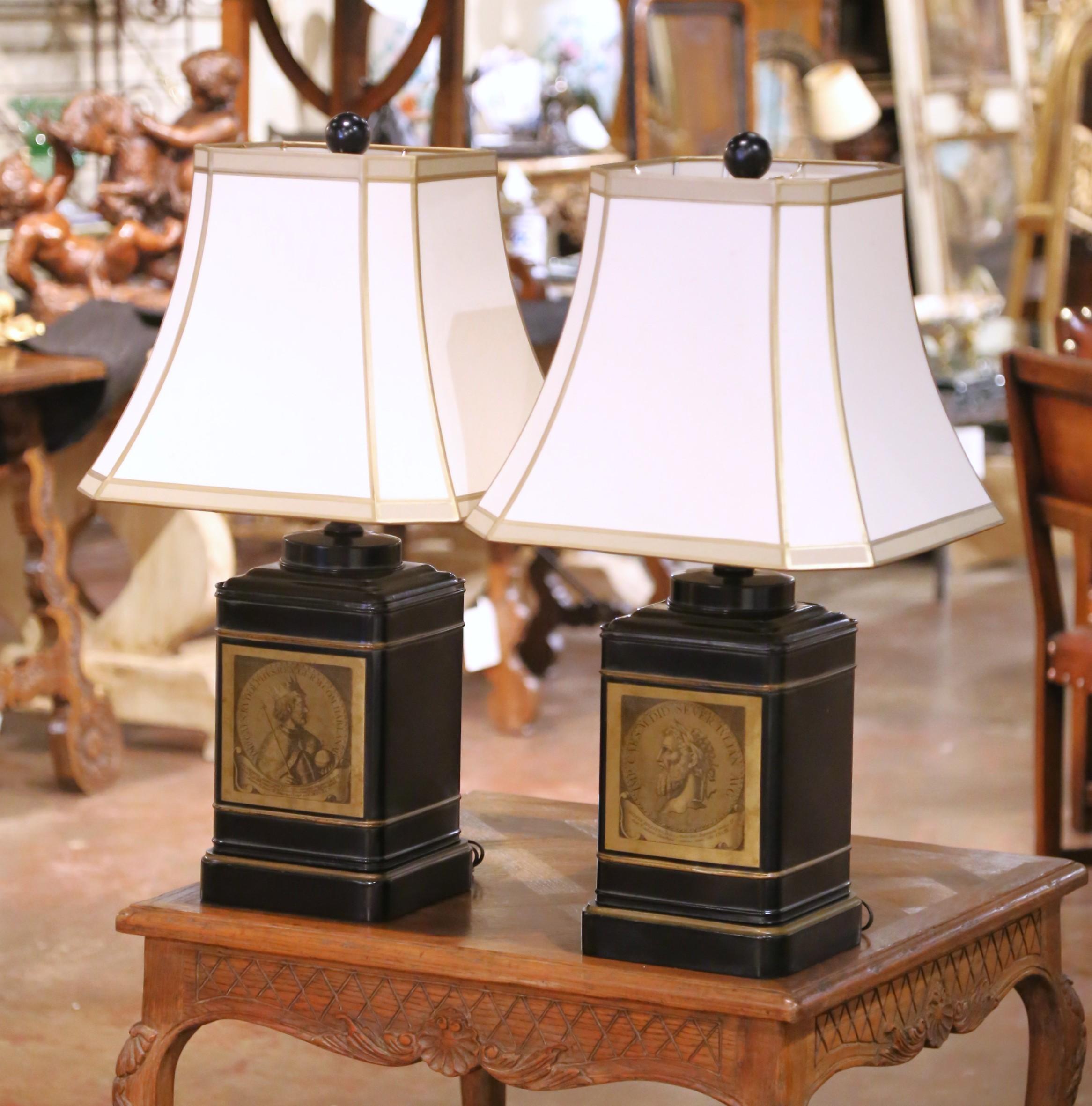 Decorate bedside tables or side tables with this elegant pair of antique tole lamps. Created in England circa 1890, each lamp features a square canister form resting on a stepped plinth base, hand-painted in deep black with fine gilt banding. The