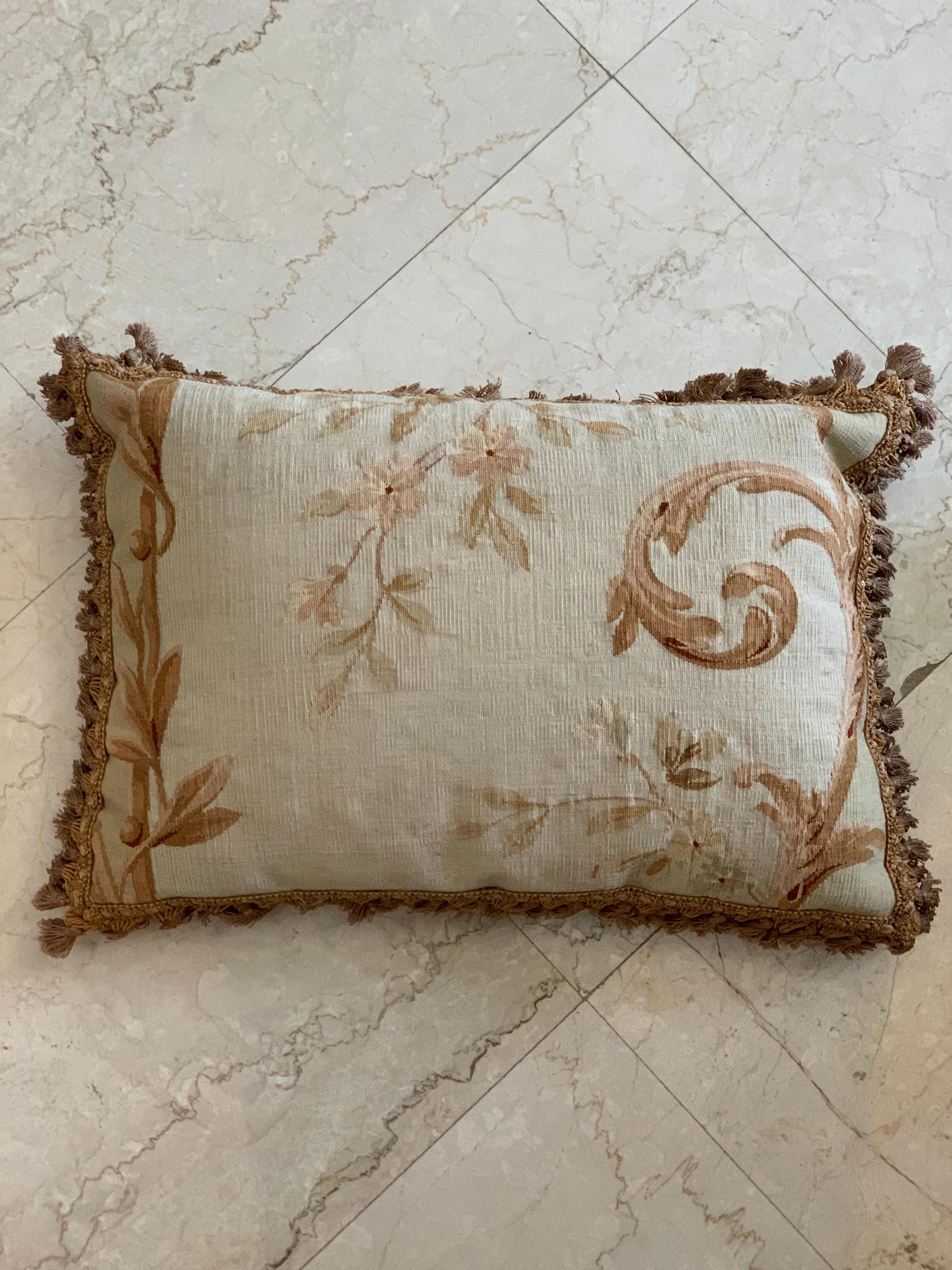 A pair of French Aubusson tapestry pillows from the 19th century, with foliage decor and petite tassels that will brighten up any sofa, canapé or settee! They are in excellent condition (one has a water stain on the backing) with gold backing and