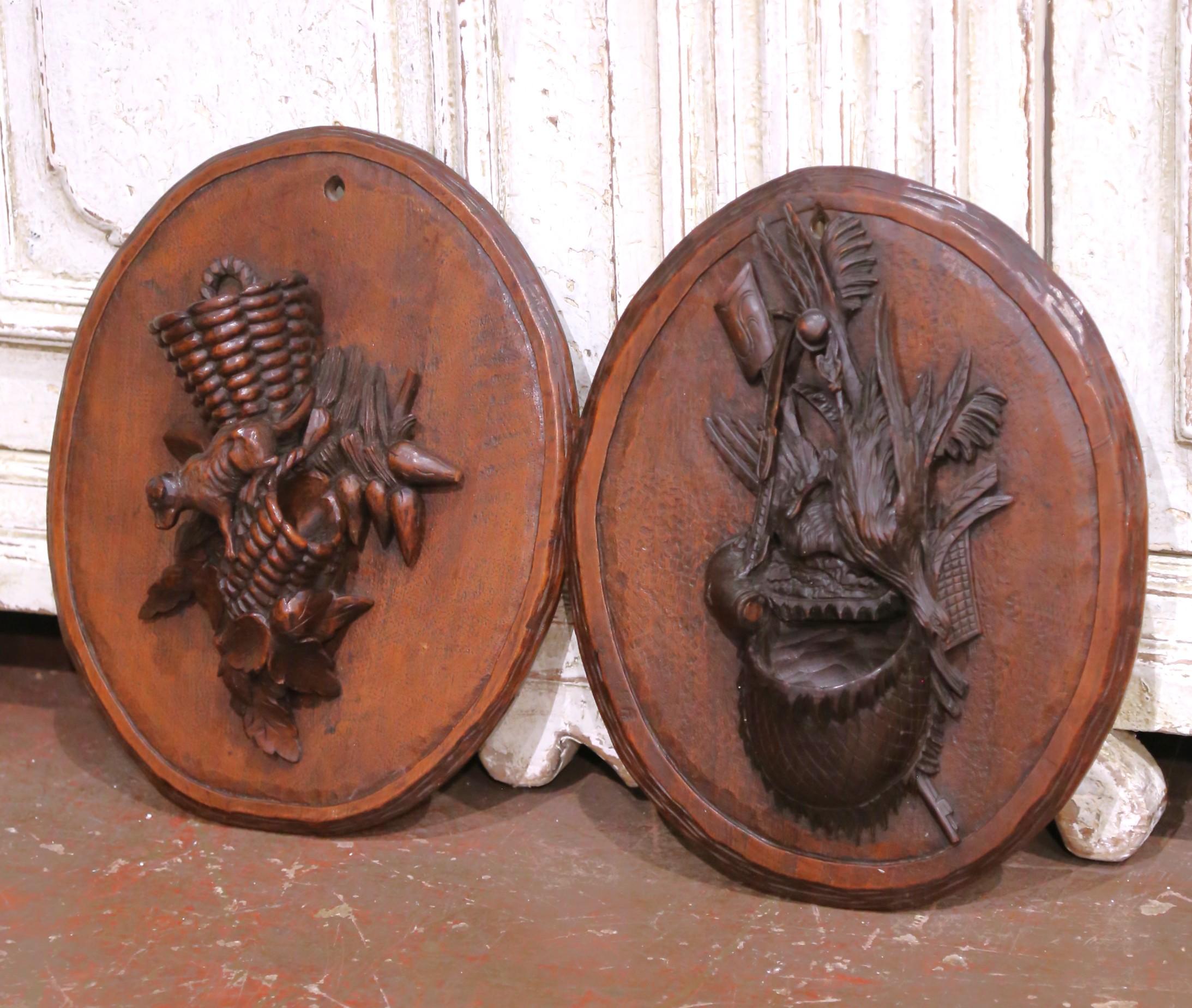 Cette paire de plaques murales antiques de la Forêt-Noire a été sculptée à la main dans du noyer massif en France vers 1870. Chacune est montée sur une plaque ovale dont le fond pointillé et ciselé met en valeur les spectaculaires sculptures en