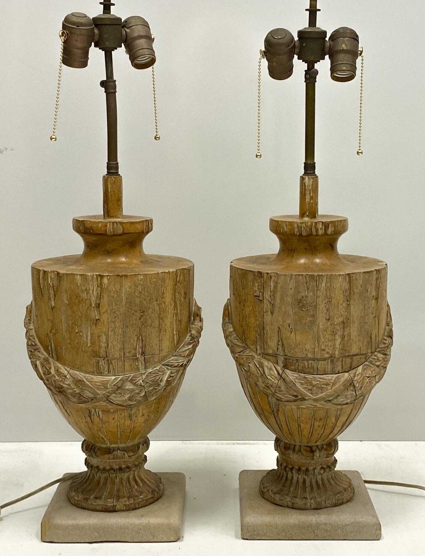 This is a pair of 19th century carved urns that have been adapted into lamps. The bases are vintage sandstone. The wiring is new. It is 18 inches to the tops of the urns, and they are 9 inches in diameter. Great patina!