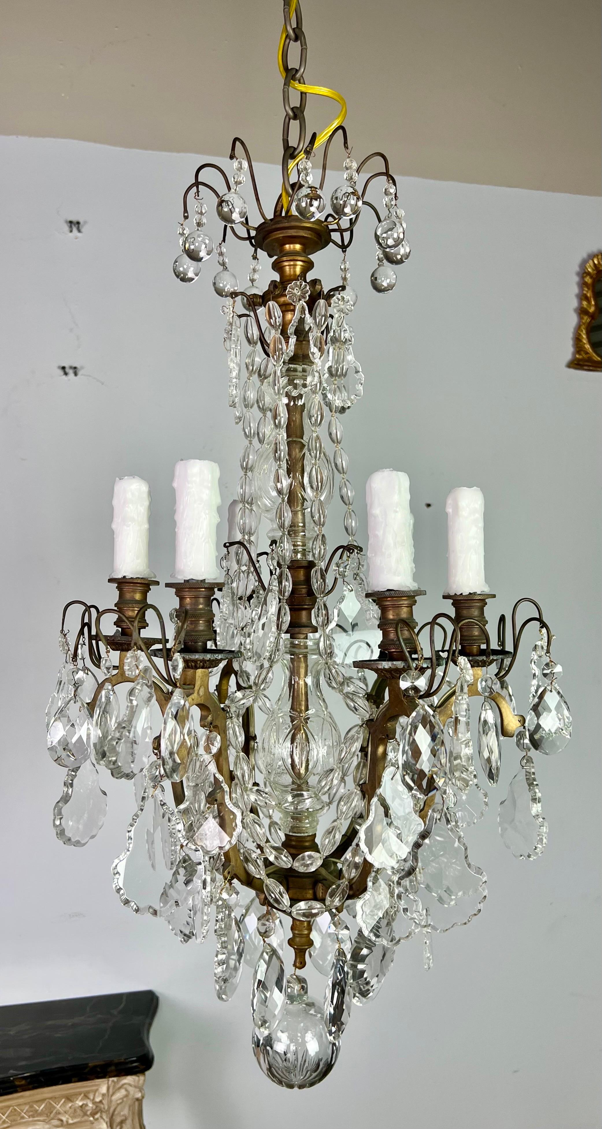 Pair of 19th century French crystal beaded bronze chandeliers. Each chandelier has six lights that have been rewired with drip wax candle covers and include chain & canopies. The chandeliers are adorned with various styles of crystals and have large