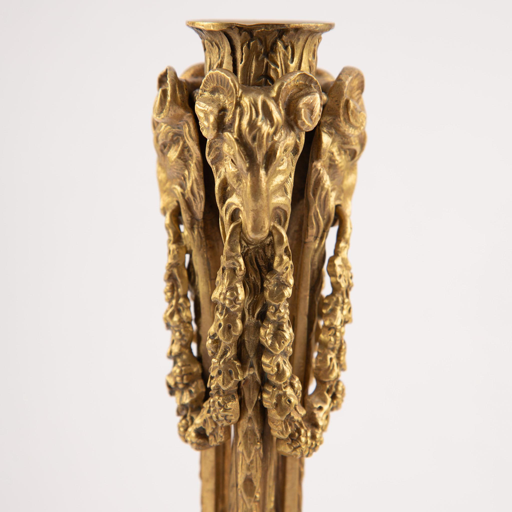 Dorato Coppia di candelieri a testa d'ariete in bronzo dorato francese del XIX secolo con motivi musicali in vendita