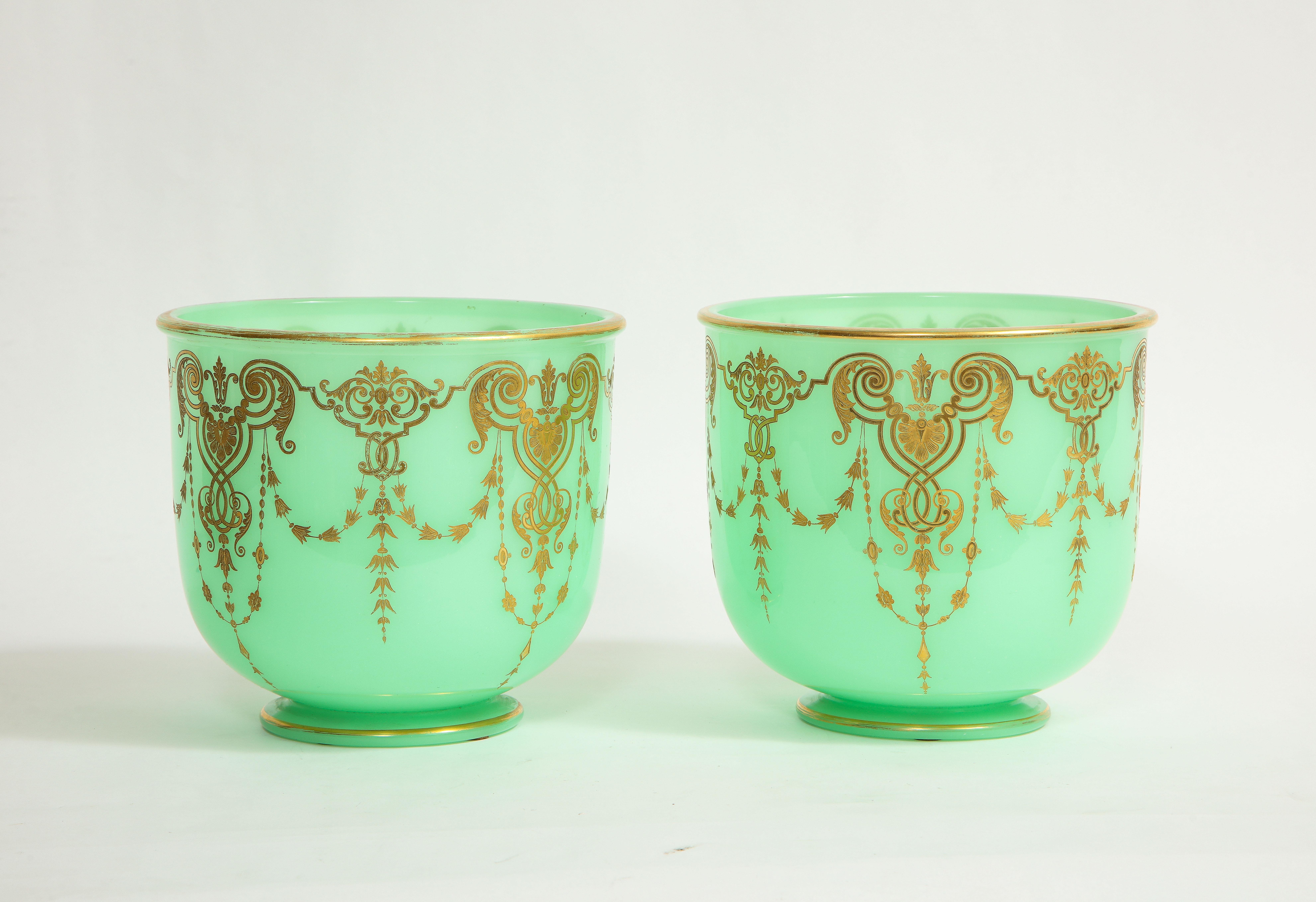 A Fantastic Pair of 19th Century Louis XVI Style French Green Opaline crystal cachepots/wine coolers with hand-engraved Neoclassical decoration and 24K Gilt Decorations. Each is beautifully made of the finest quality of green opalescent crystal and