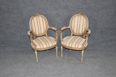 Paire de fauteuils Louis XVI français du 19e C. décorés à la peinture et sculptés en vermeil