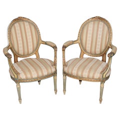 Paire de fauteuils Louis XVI français du 19e C. décorés à la peinture et sculptés en vermeil