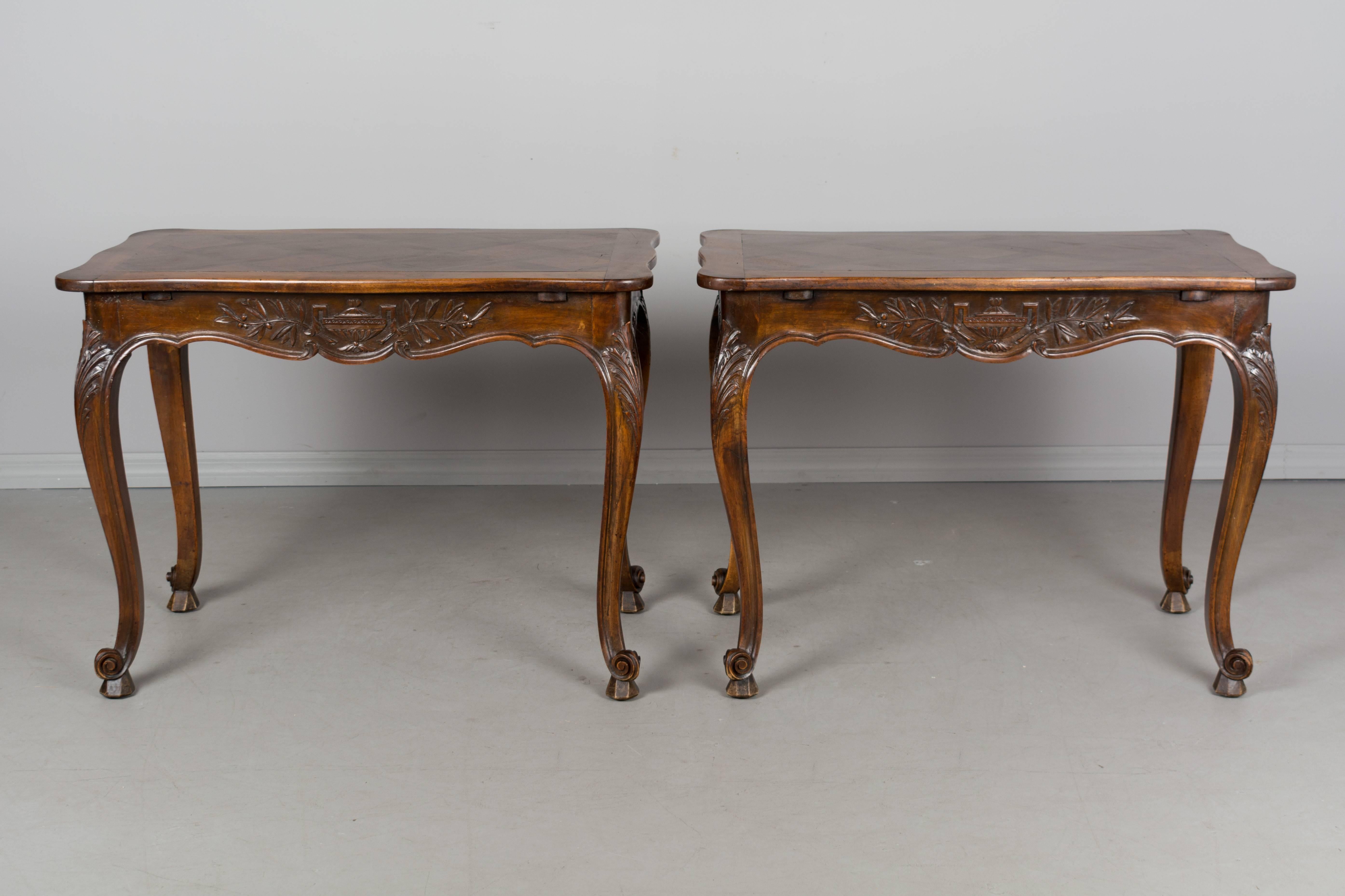 A pair of 19th century French Louis XV style parquet top tables from Provence. Made of solid walnut and veneer of walnut with waxed finish. Nice carved relief of an urn with olive branches on the apron of both sides. Curved legs with large carved