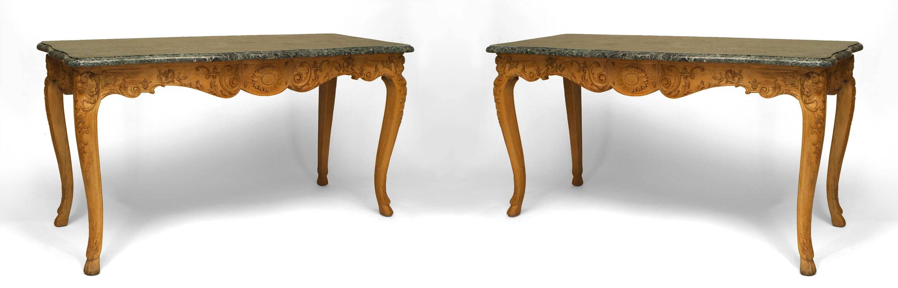 Paire de consoles en chêne strié de style Louis XV (19ème siècle) avec un plateau en marbre vert serpentin au-dessus d'un tablier sculpté de fleurs de tournesol sur des pieds cabriole avec des pieds sabots (prix pour la paire).   
  