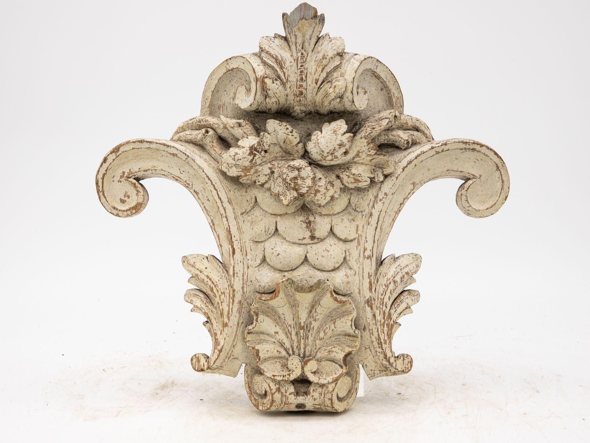 A captivating pair of 19th-century woodwork corbels invites admiration with their rustic charm. These exquisite architectural elements bear witness to the craftsmanship of the era, each intricately carved. The weathered paint finish adds character,