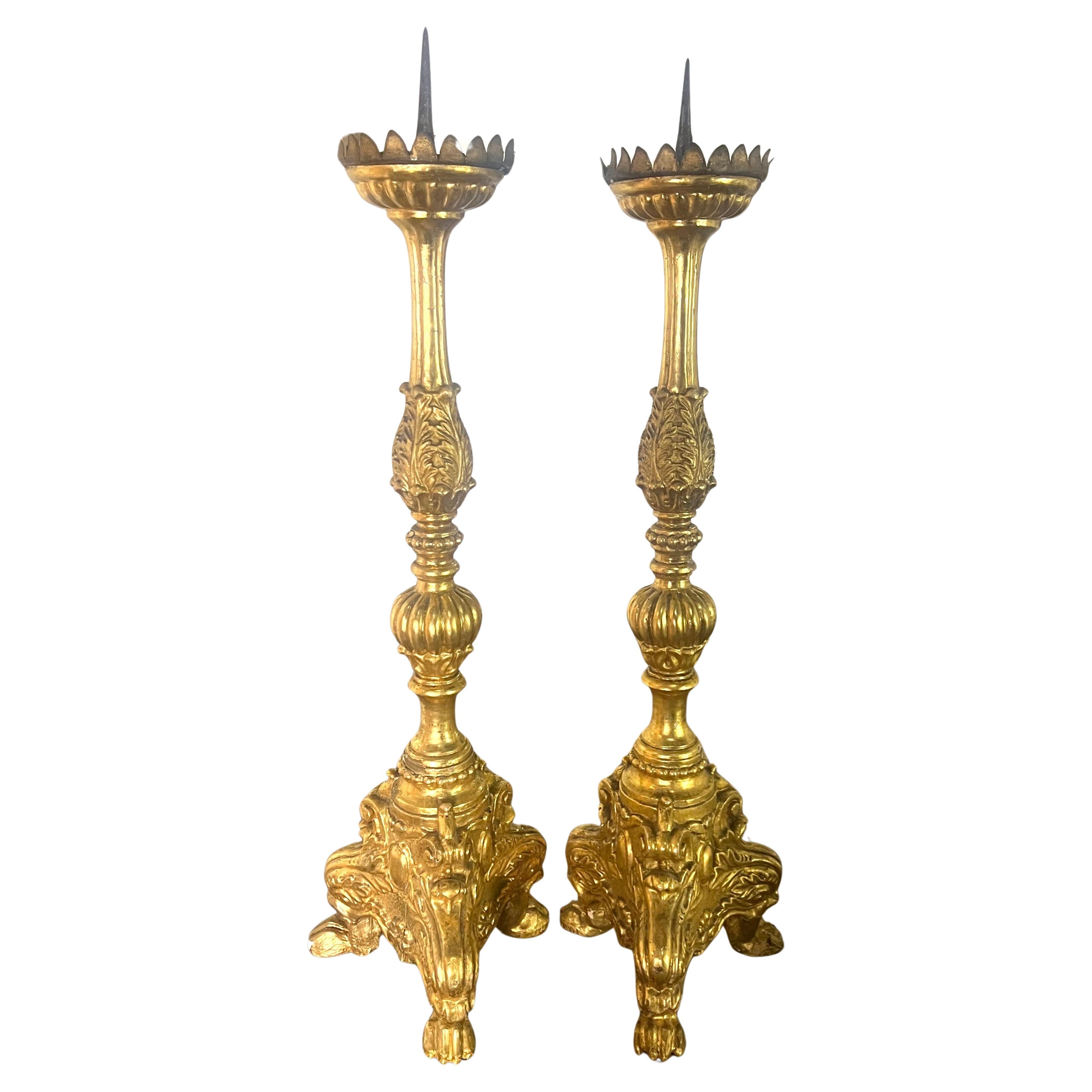 Coppia di candelieri in legno dorato italiano del XIX secolo.  Il design è molto decorativo, con intagli dettagliati lungo tutta la lunghezza del candeliere.

La base è grande e robusta, con un intricato piede a forma di artiglio in ogni angolo, che