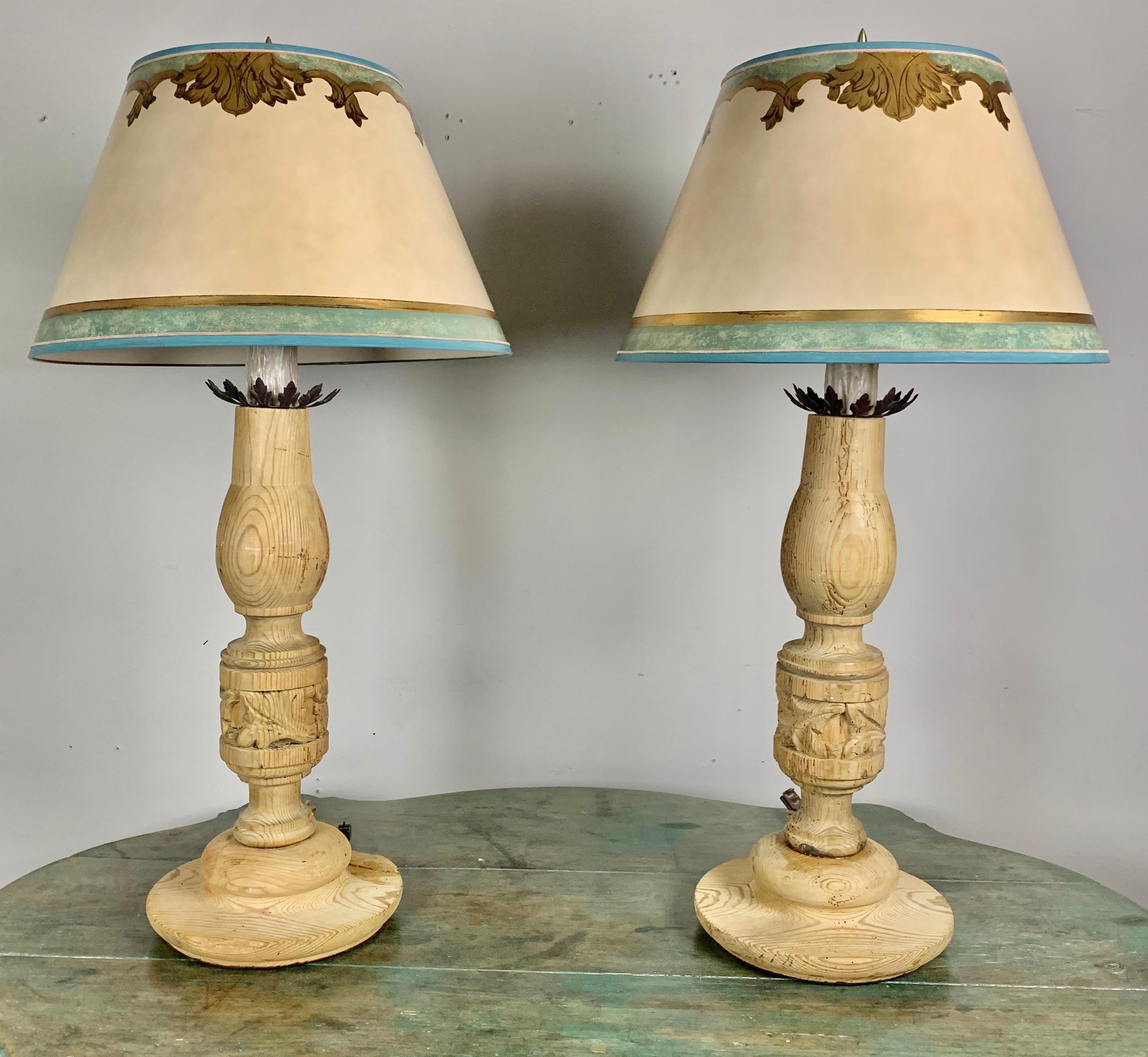 Pair of custom lamps made with a pair of 19th century hand carved Italian candlesticks wired into lamps and crowned with hand painted parchment shades. Newly wired for electricity and ready to install.