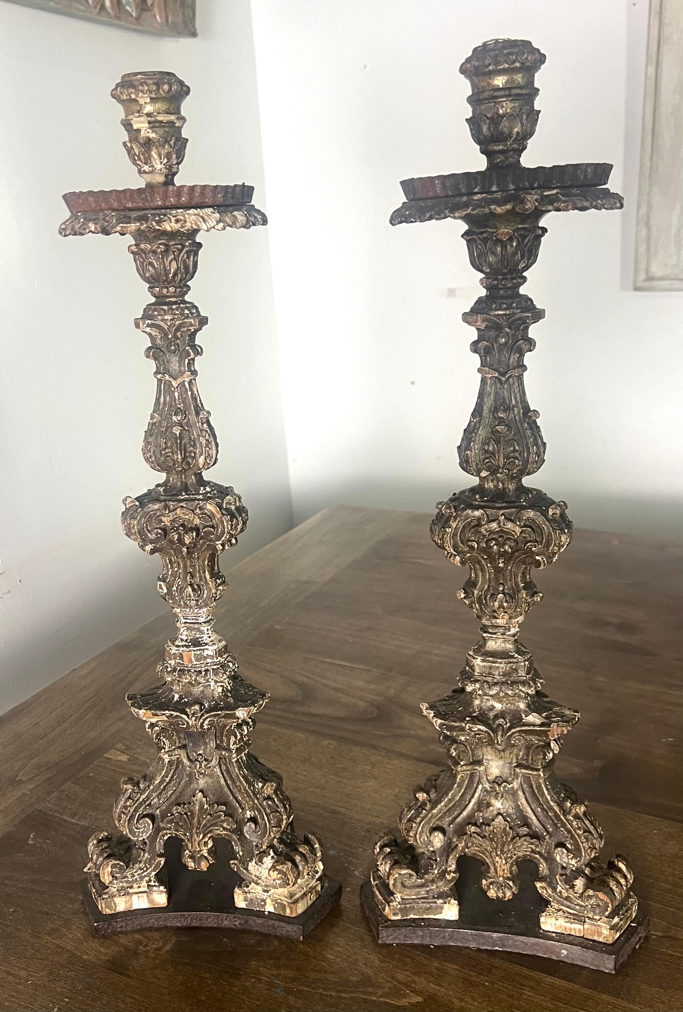 Paar italienische Kerzenhalter im Barockstil aus dem 19. Jh. mit elegantem Schnörkelwerk, floralen Motiven und einer mehrstufigen Struktur.  Jeder Kerzenständer hat einen breiten, dekorativen Sockel mit geschwungenen Füßen und kunstvollen