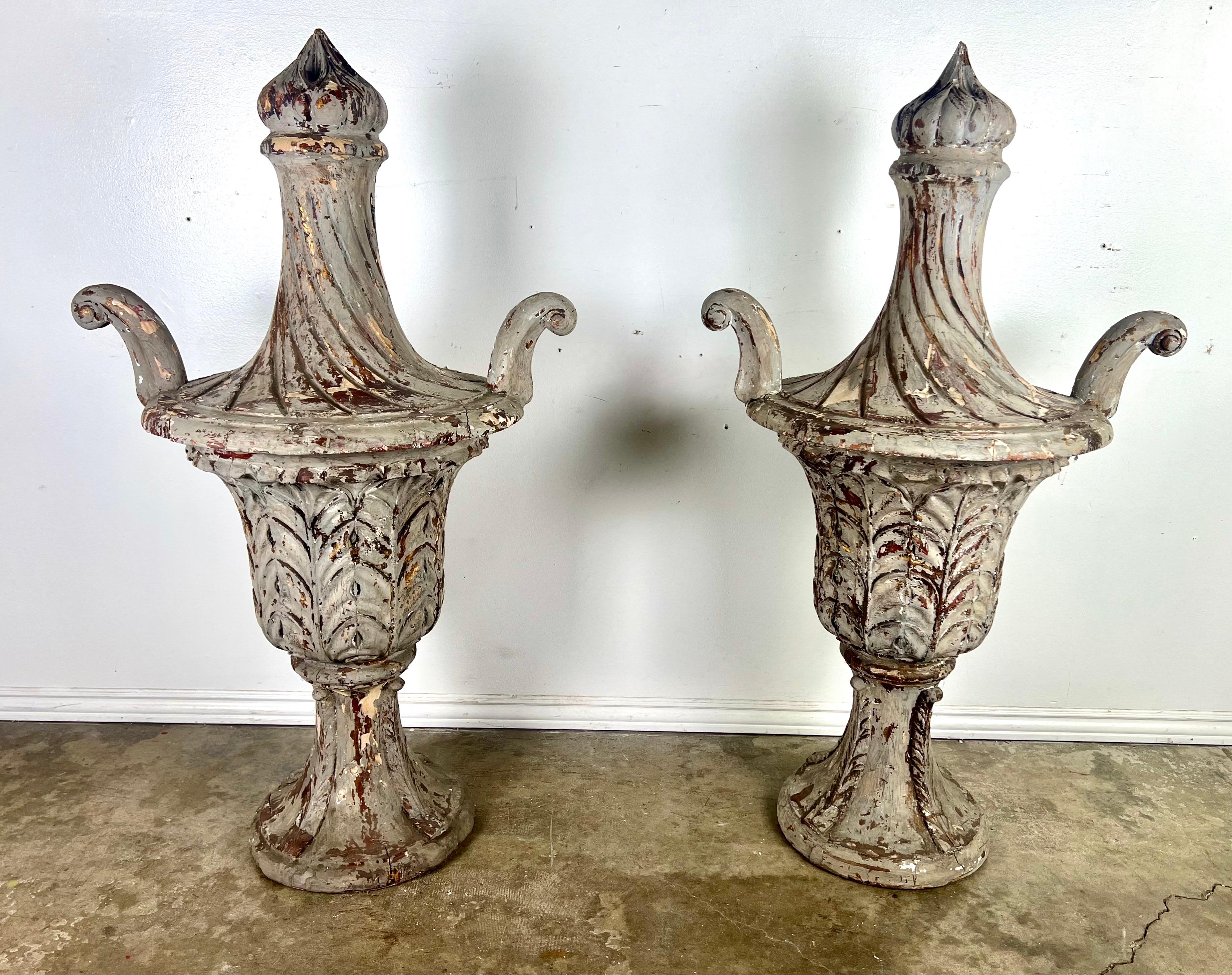 19th-century Italian neoclassical finials, each meticulously carved from wood, their design epitomizing the grandeur and refined aesthetics of the neoclassical movement.  These finials stand out with their distinct features: arms elegantly flared
