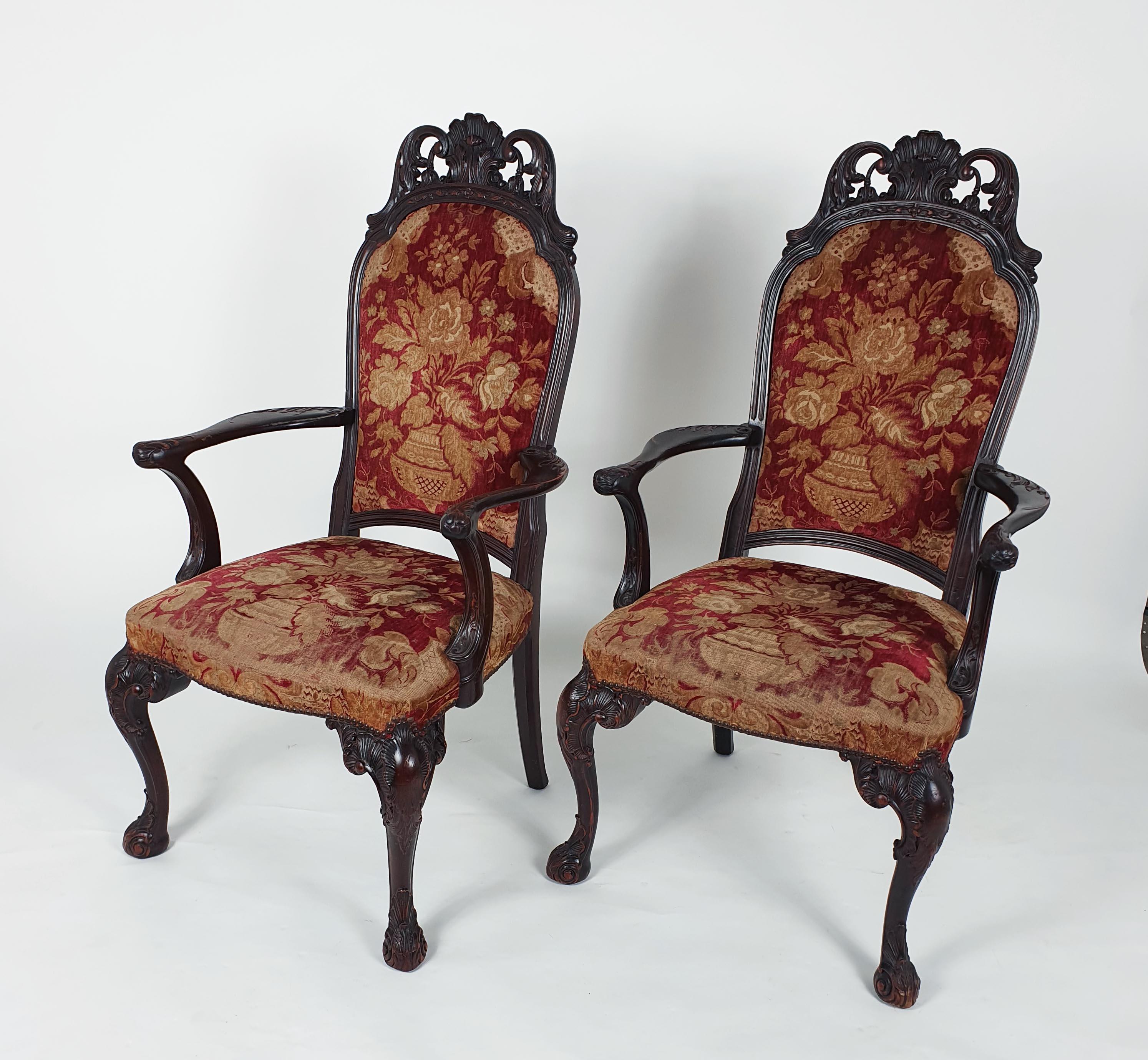 This beautiful set of 19th century Italian carved walnut armchairs feature pierced and carved cresting rails, supported on ornately carved front cabriole legs with shell detail and swept back legs. The worn cut velvet upholstery is original,