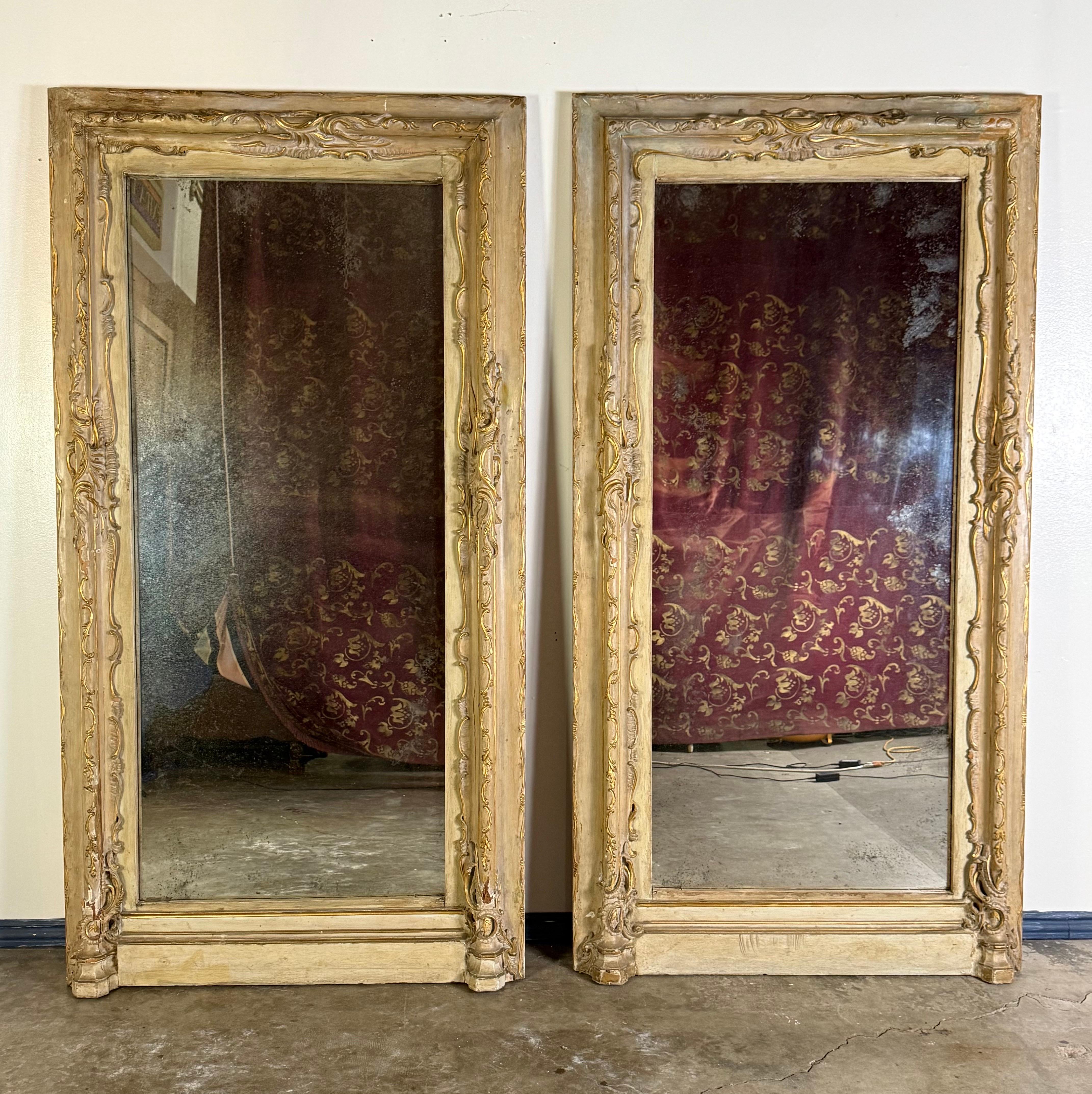 Paire de miroirs italiens monumentaux du 19ème siècle avec verre antique.
Cette paire saisissante de miroirs monumentaux a d'abord été utilisée comme encadrement de porte italienne du XIXe siècle, avant d'être transformée avec art en miroirs muraux