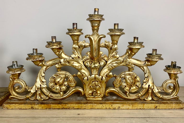 Pair of 19th century Italian hand carved candleholders. They are both finished in 22-karat gold leaf and hold nine candles each. They originally sat on the alter of a beautiful Italian church but would make a great accent in any style home. I can