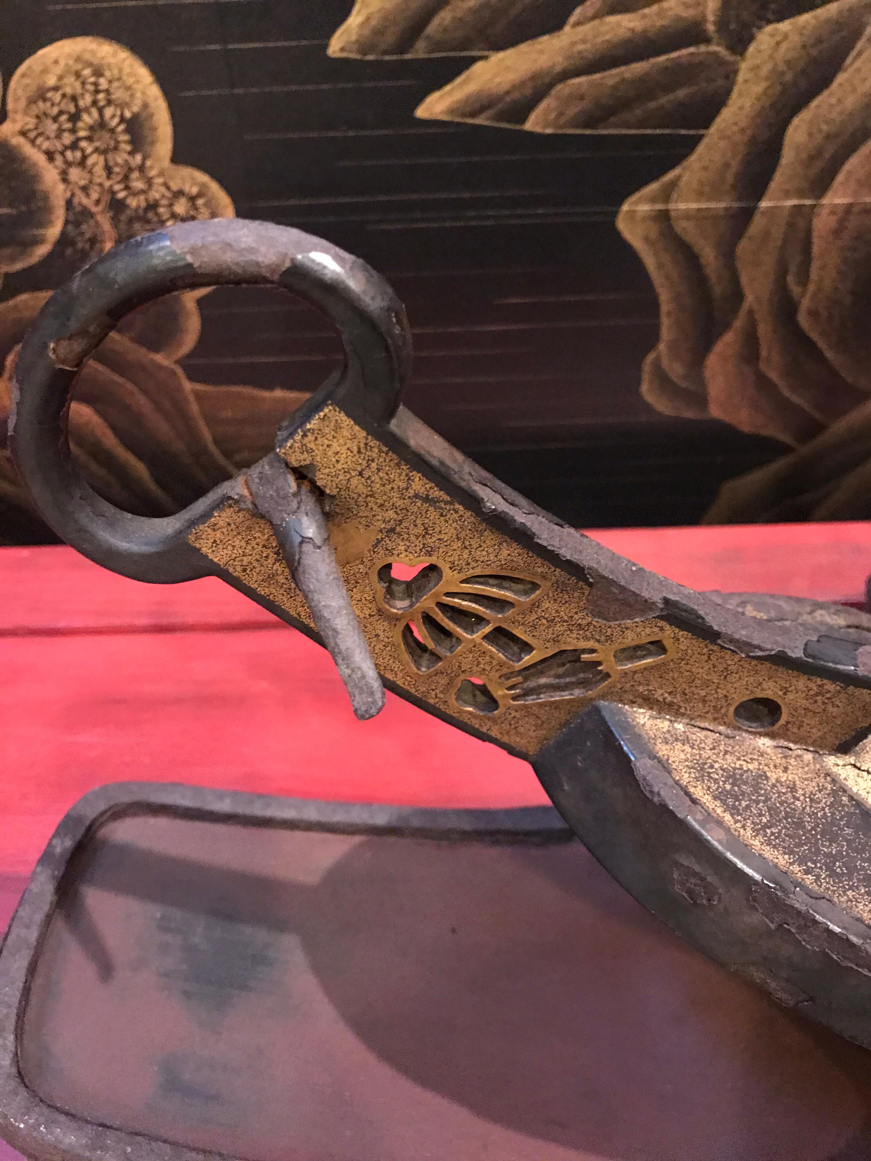 Abumi (Samurai horse riding stirrups) are a graceful shape, and make for a stunning accent on a shelf or table. This pair are made of metal, and covered inside with red lacquer, and outside with black and gold lacquer.

The gold crest is a family