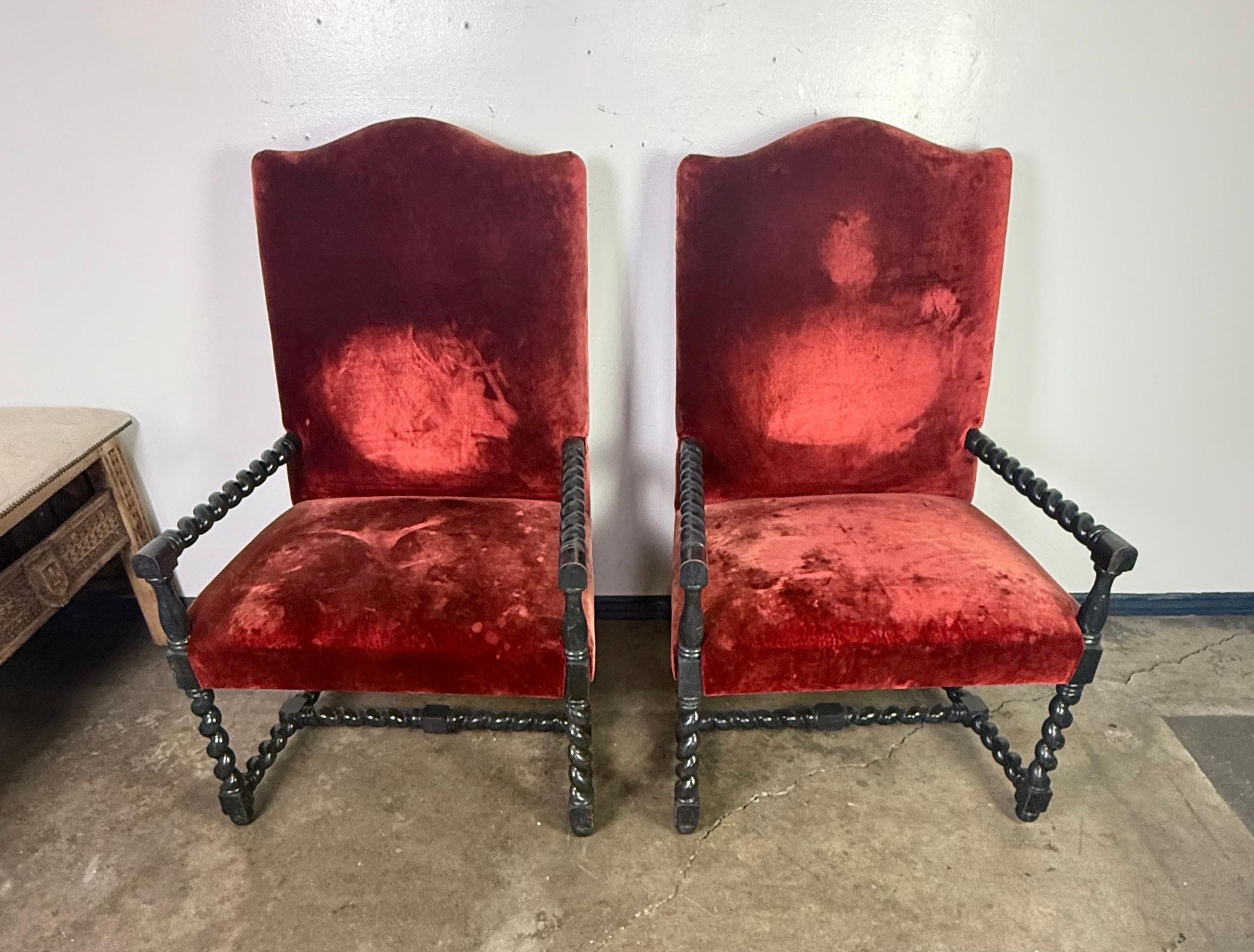 Queste poltrone sono esempi classici di sedute in stile barocco, probabilmente di origine francese o spagnola, risalenti al XIX secolo.  La ricca tappezzeria in velluto rosso è tipica dell'opulenza barocca, anche se presenta segni di usura e