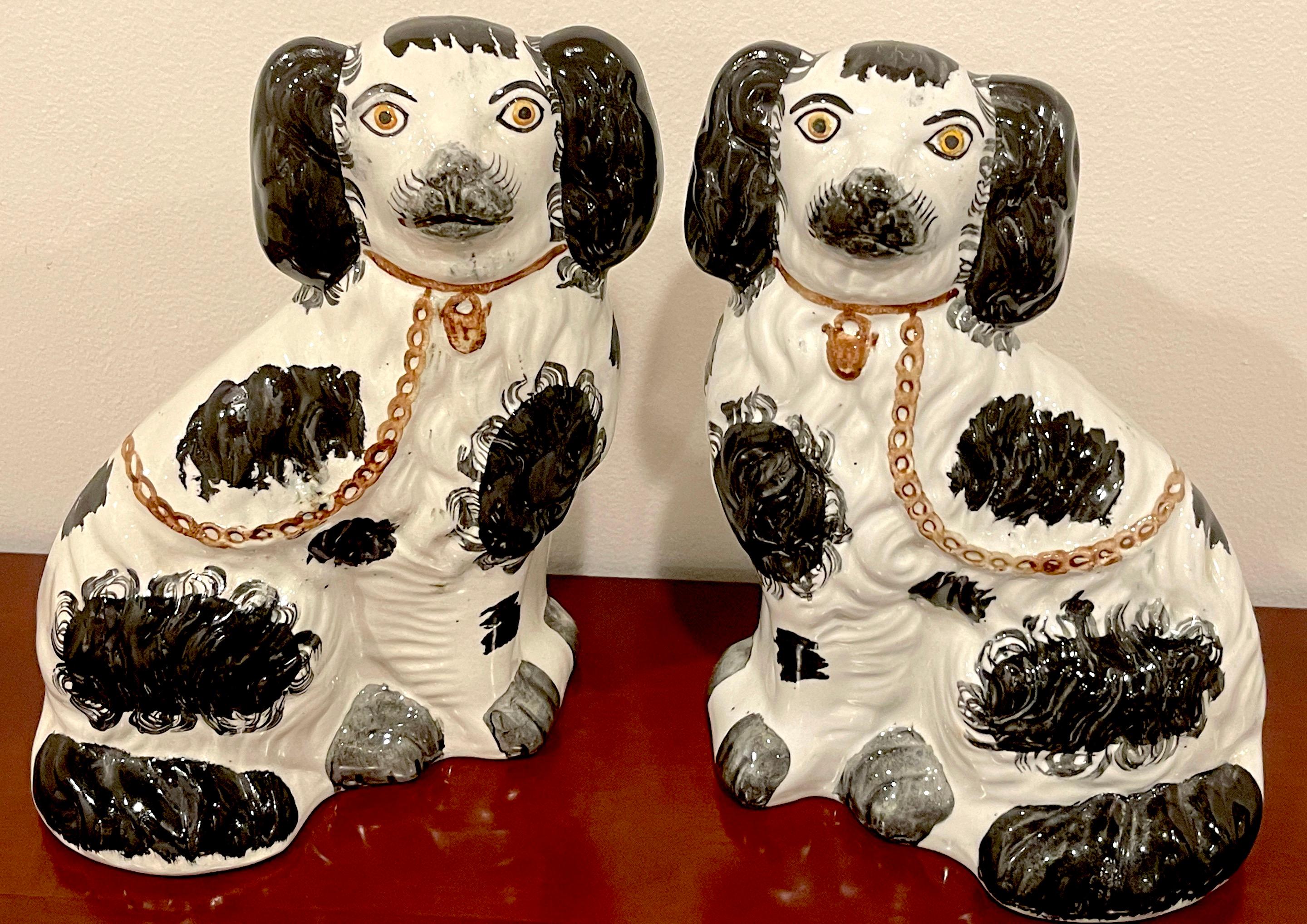 Pair of 19th C Staffordshire black & white spaniels, A nice variation of the more common Staffordshire dogs, This pair painted with expressive yellow eyes, with chain and lock collars, and black 'sponge' decoration. Unmarked, of the the period.