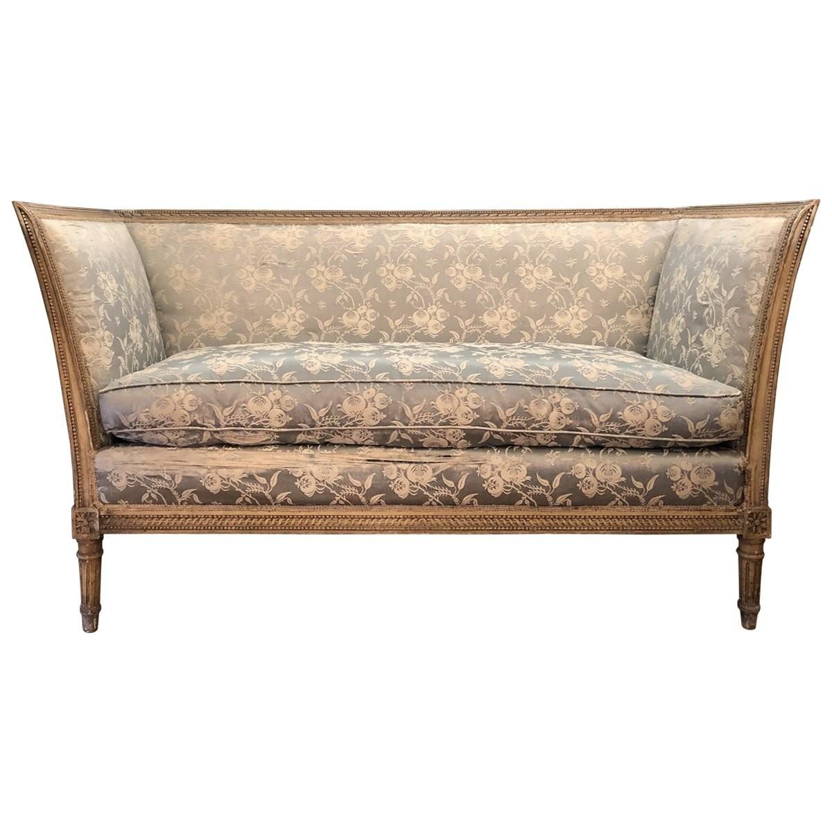 These carved and painted settees exude the decadent and luxurious grace of the Louis XVI era. These carved and painted Louis XVI settees come with a low back. The settees consist of loose and zippered down-filled seats in powder blue and cream silk