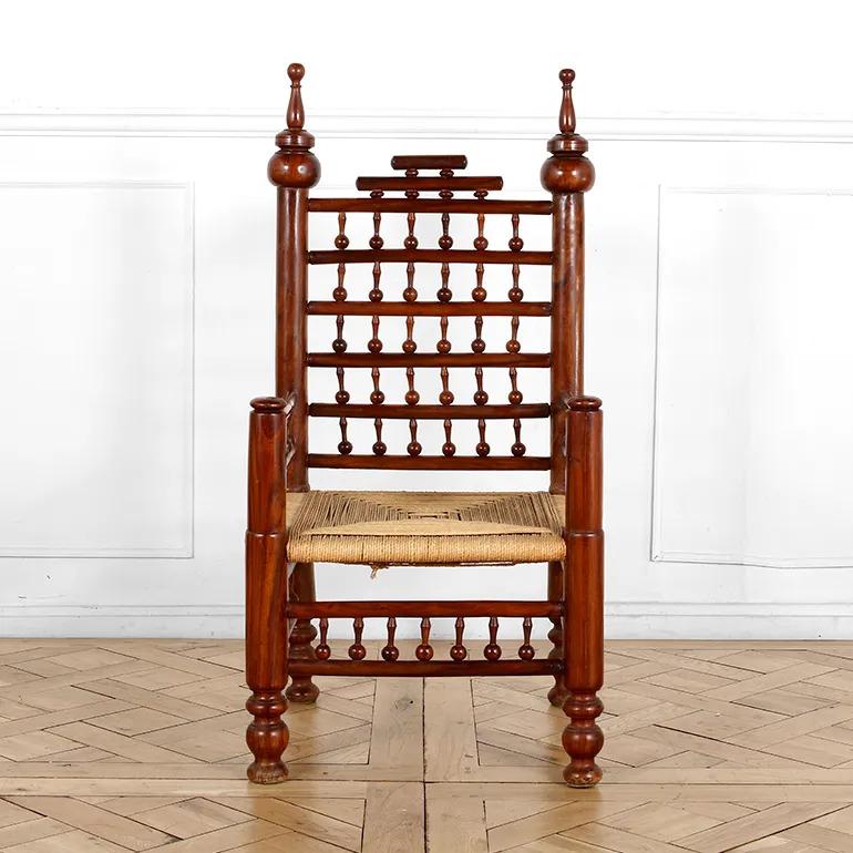 Un'impressionante coppia di poltrone con schienale a fuso in noce massiccio, realizzate in legno duro riccamente patinato con intricati dettagli torniti. Queste sedie sono caratterizzate da montanti con decorazioni audaci, fusi a spola graduati e