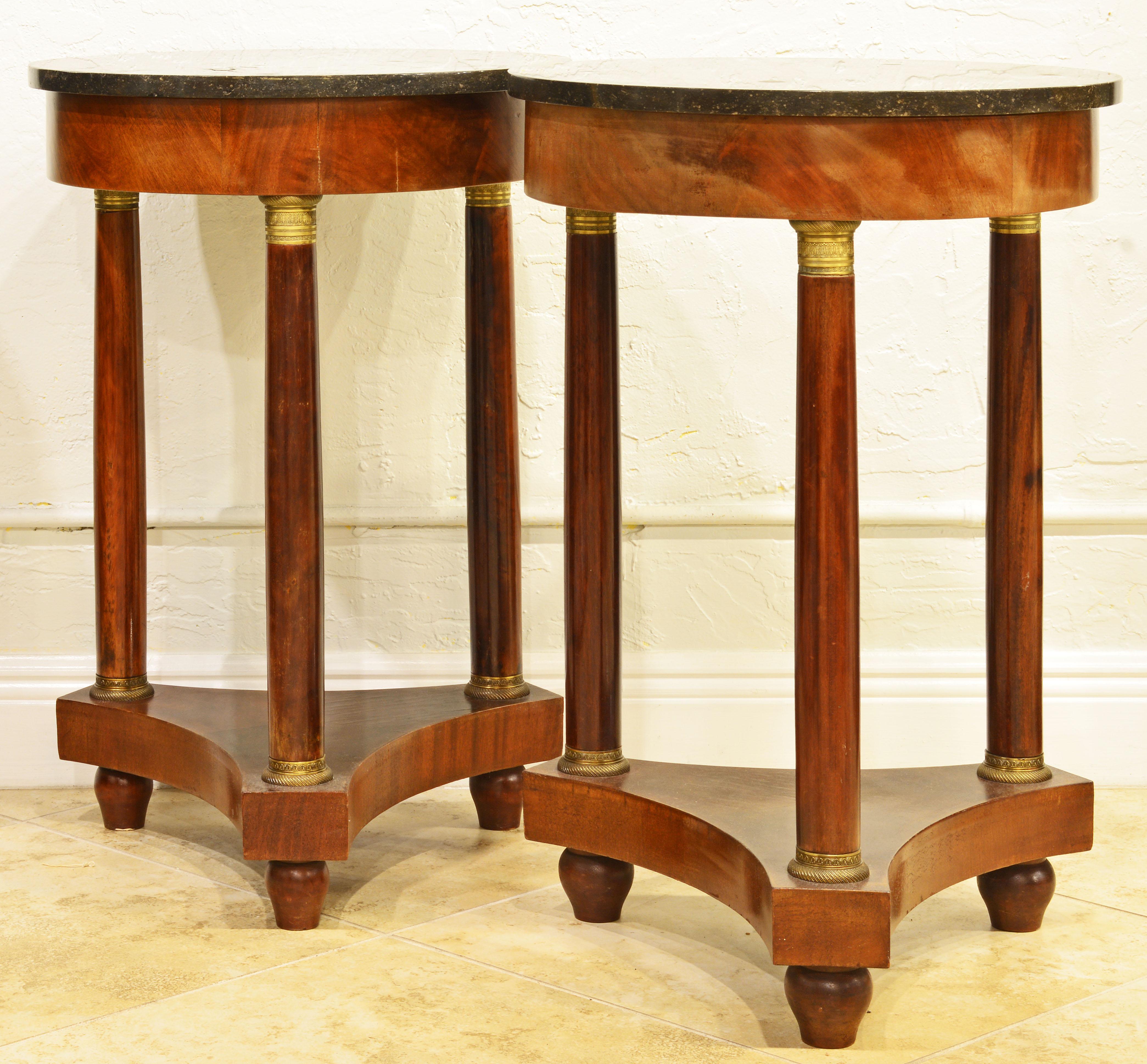 A lovely pair of French Empire style round mahogany marble-top tables on three gilt bronze mounted columns and a shaped base with turned feet.