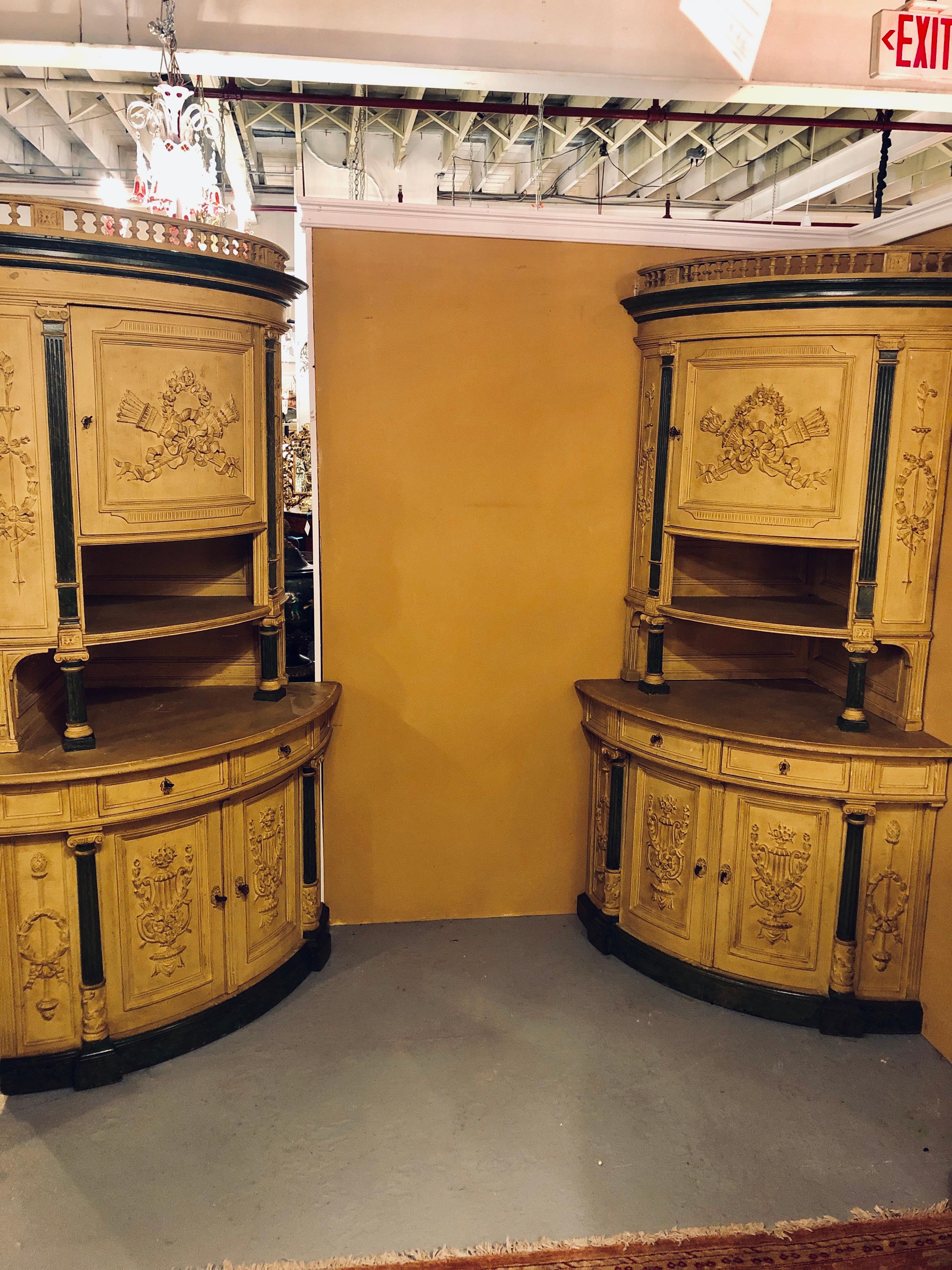 Pair of 19th century monumental Louis XVI style paint decorated corner cabinets having faux marble columns. These are simply breathtaking and certainly will never be seen again. The fine Louis XVI Style carvings of floral torch and wreath design are