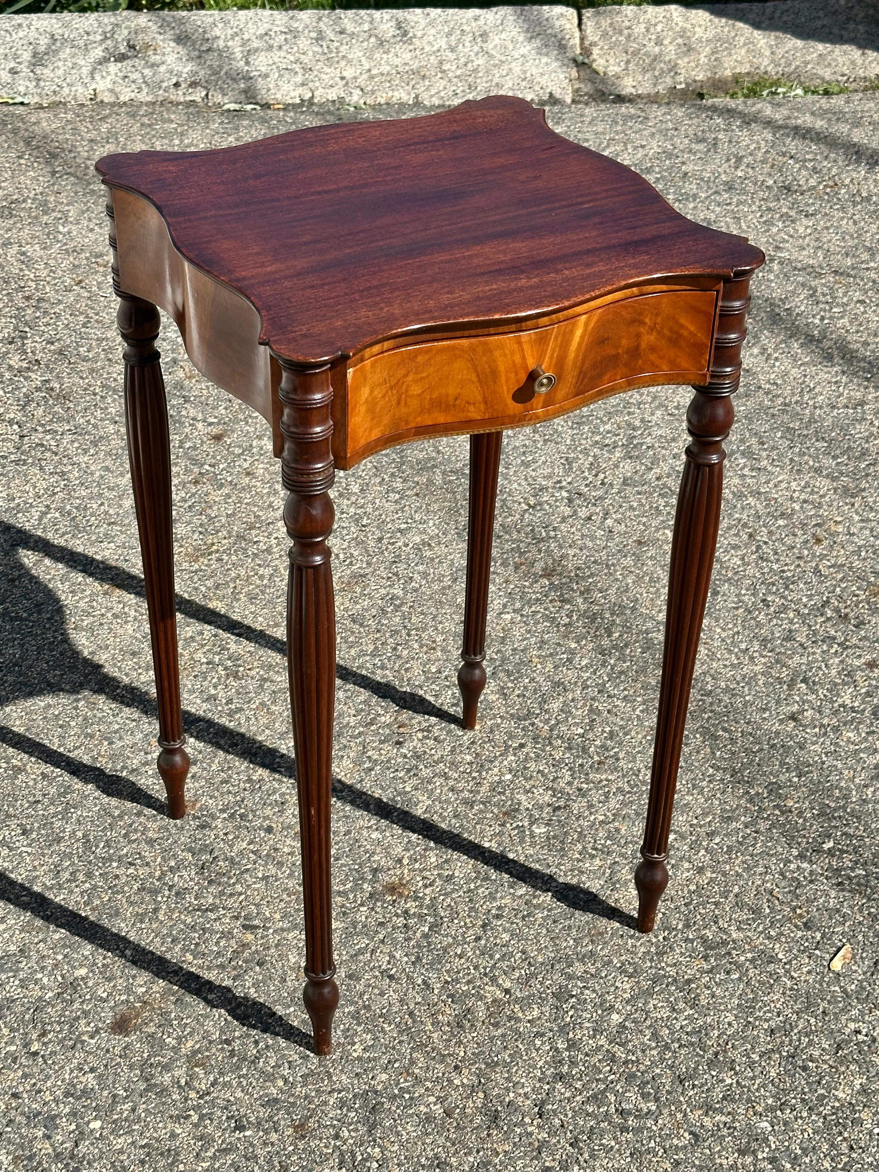 Pair of 19th Century American Federal Style Side Tables.  North Shore of Massachusetts.  Reeded tapered legs, cookie corner tops, decorative flame birch on all four serpentine sides.  Dovetailed drawer with pine secondary construction. 

Provenance: