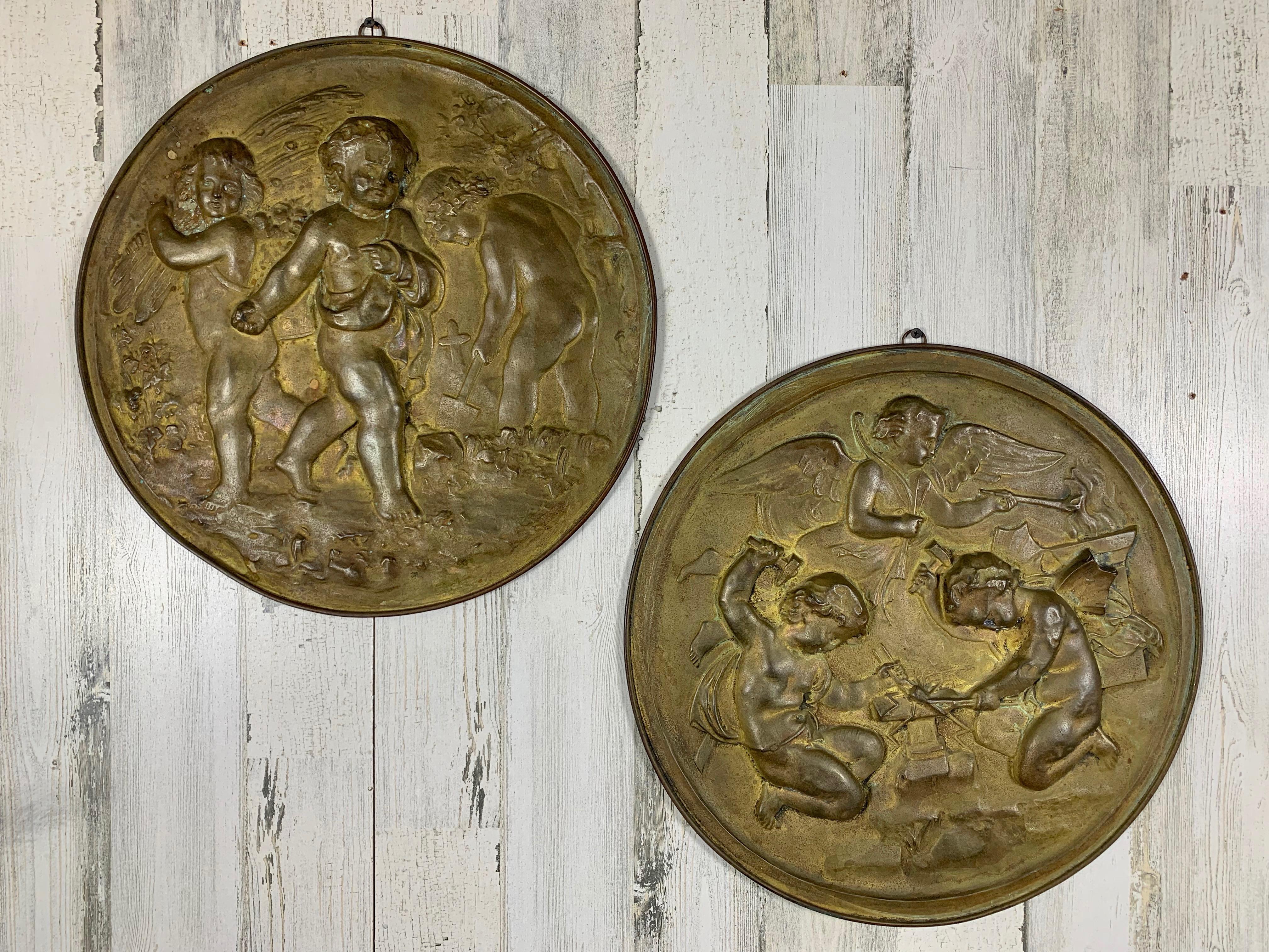 Belle Époque Pair of 19th Century Angels at Work Brass Repousse Decorative Rounds For Sale