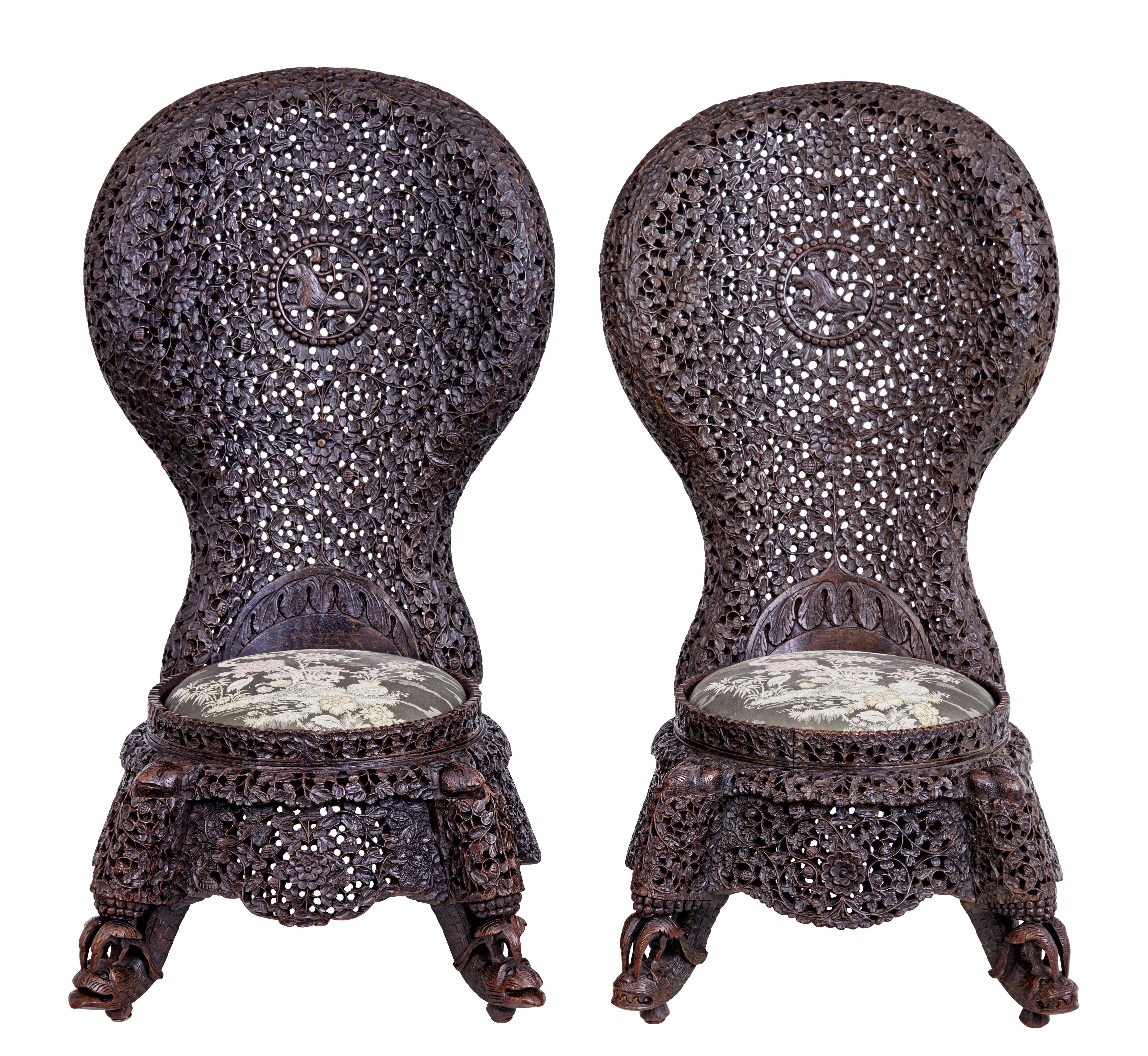 Pair of 19th century Anglo-Indian carved hardwood chairs, circa 1890.

Stunning pair of low Anglo-Indian nursing chairs. Profusely pierced carved shaped backs with carved lion with beaded surround in the centre. Drop in seat with oriental inspired