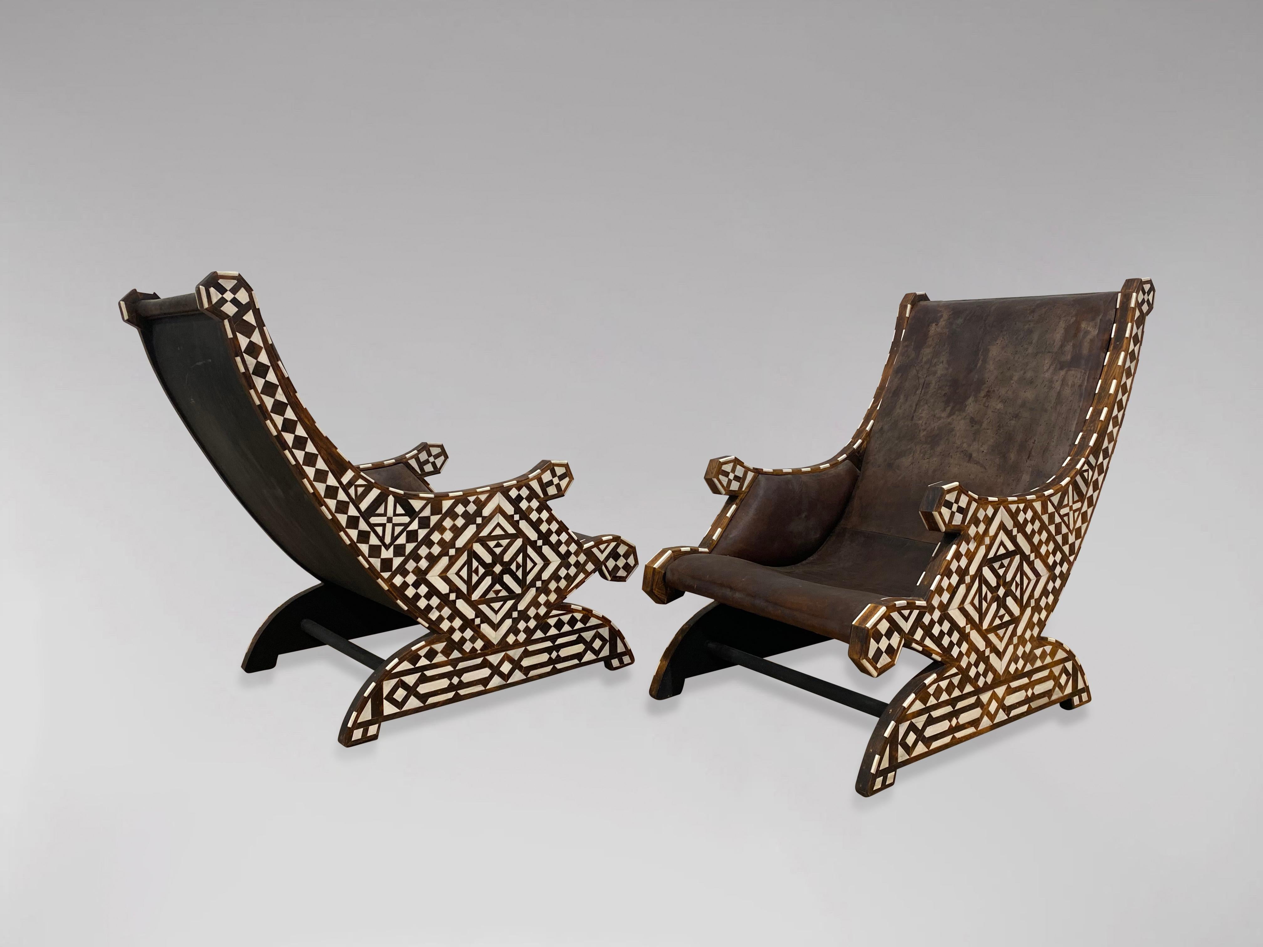 A rare pair of 19th century British Colonial solid rosewood lounge armchairs with bone inlaid designs patterns throughout, with allover geometrical bone inlay. The frame banded with rosewood and bone, side arm panels comprising two lovely shaped arm