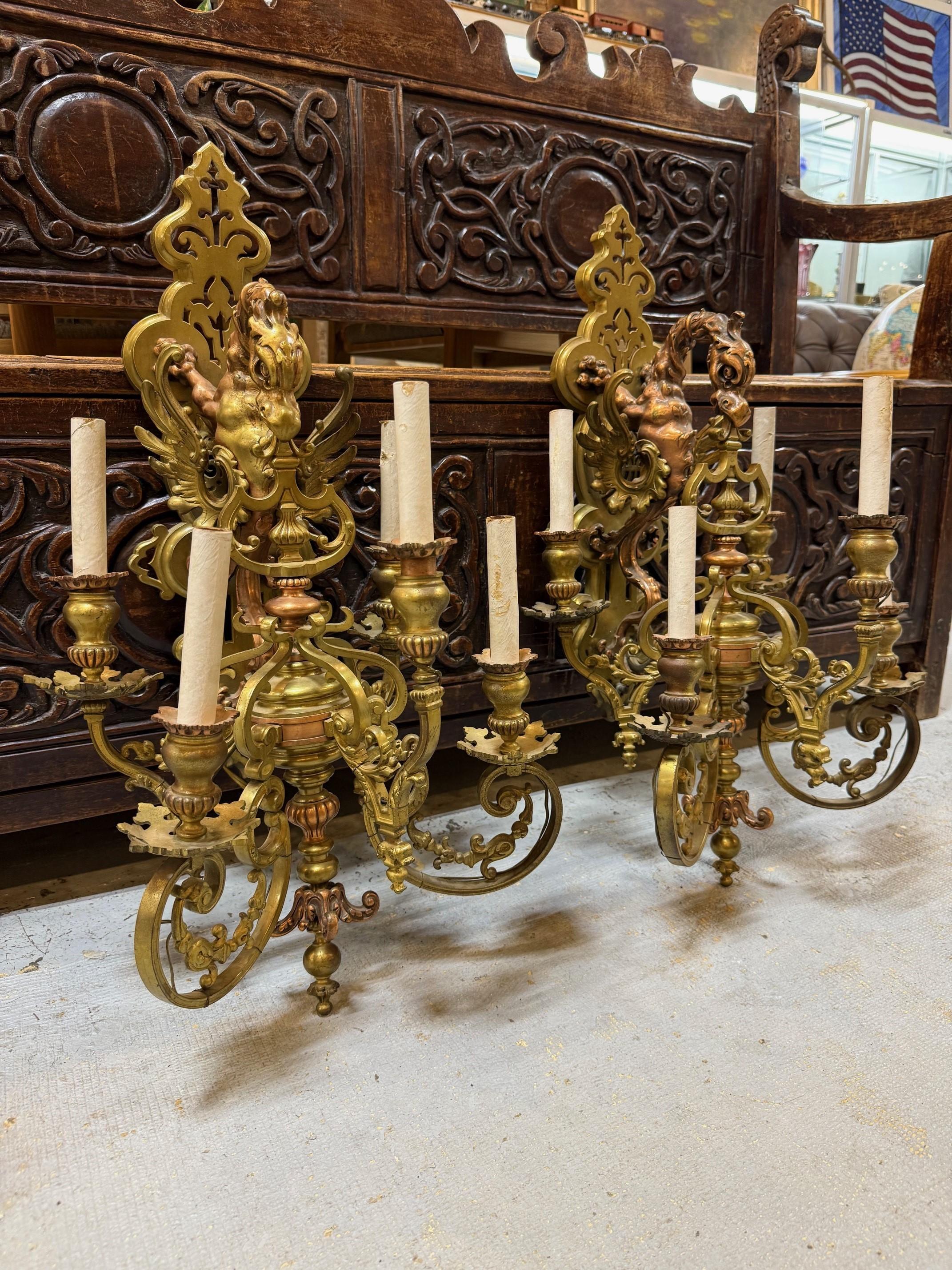 Magnifica coppia di appliques in bronzo e rame del XIX secolo con grifone o doccione che regge un candelabro a 5 luci. La lavorazione è straordinaria e utilizza sia il rame che il bronzo per un look unico. Sono stati cablati anni fa e hanno un