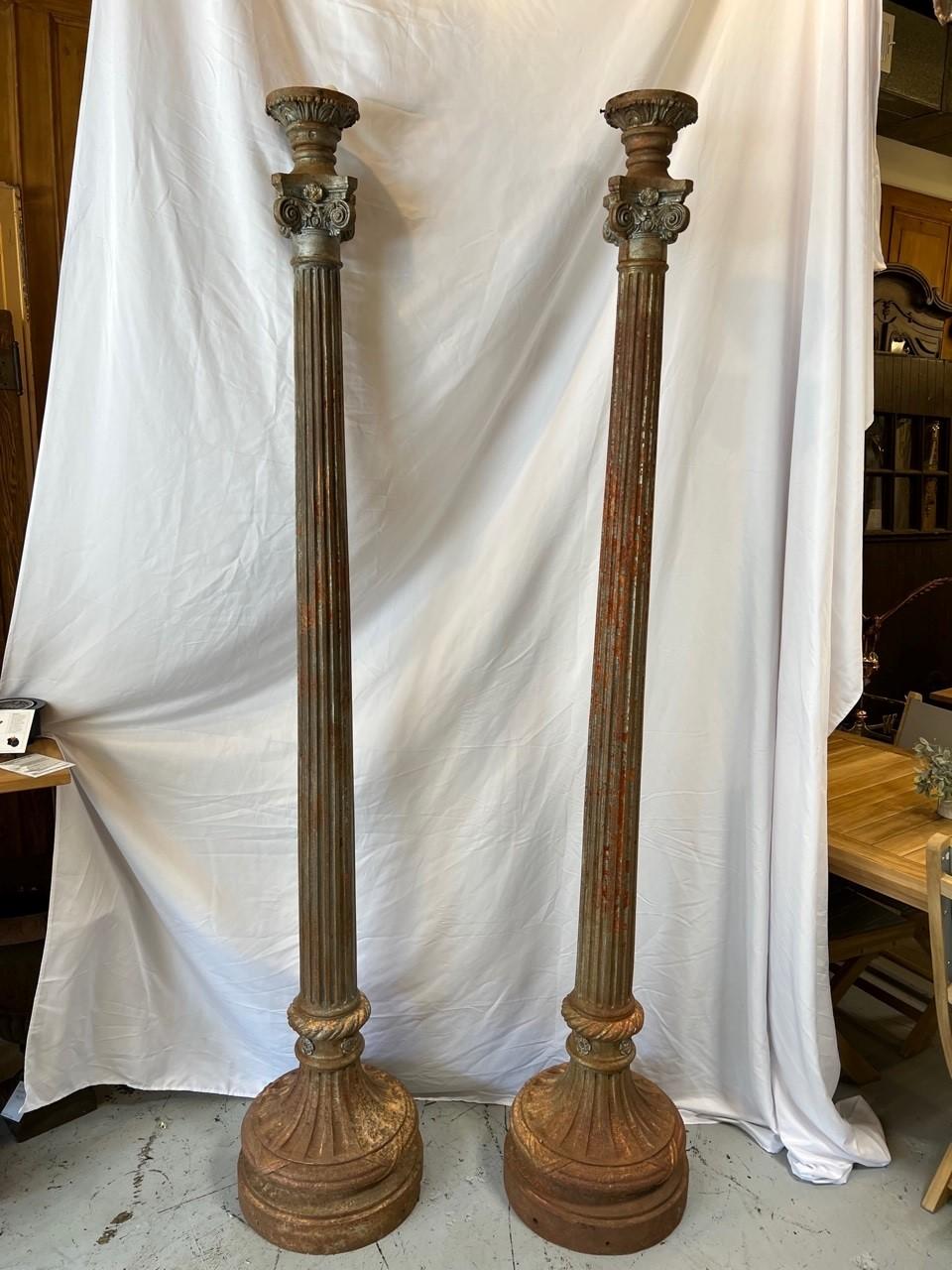 A great pair of antique cast iron lamp posts in very good condition. Pairs of antique cast iron lamp posts are hard to fined. This is a nice pair with a capital on top and fluted columns with a round base. They would need to be rewired and one post