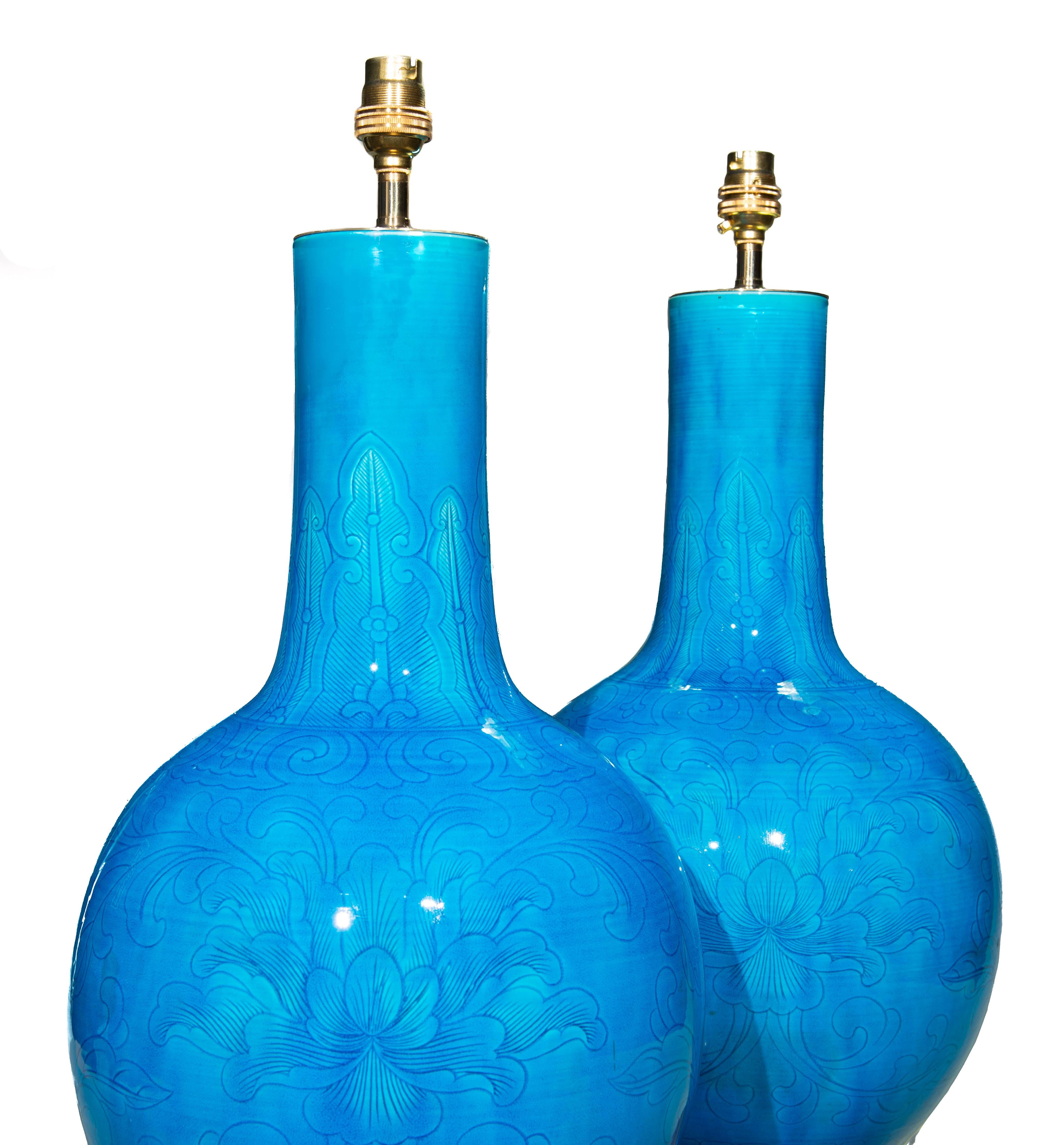 Superbe paire de vases en porcelaine chinoise de la fin de la dynastie Qing, avec une magnifique glaçure turquoise et un subtil décor de lignes florales et de feuillages tourbillonnants, aujourd'hui montés comme lampes sur des bases en bois