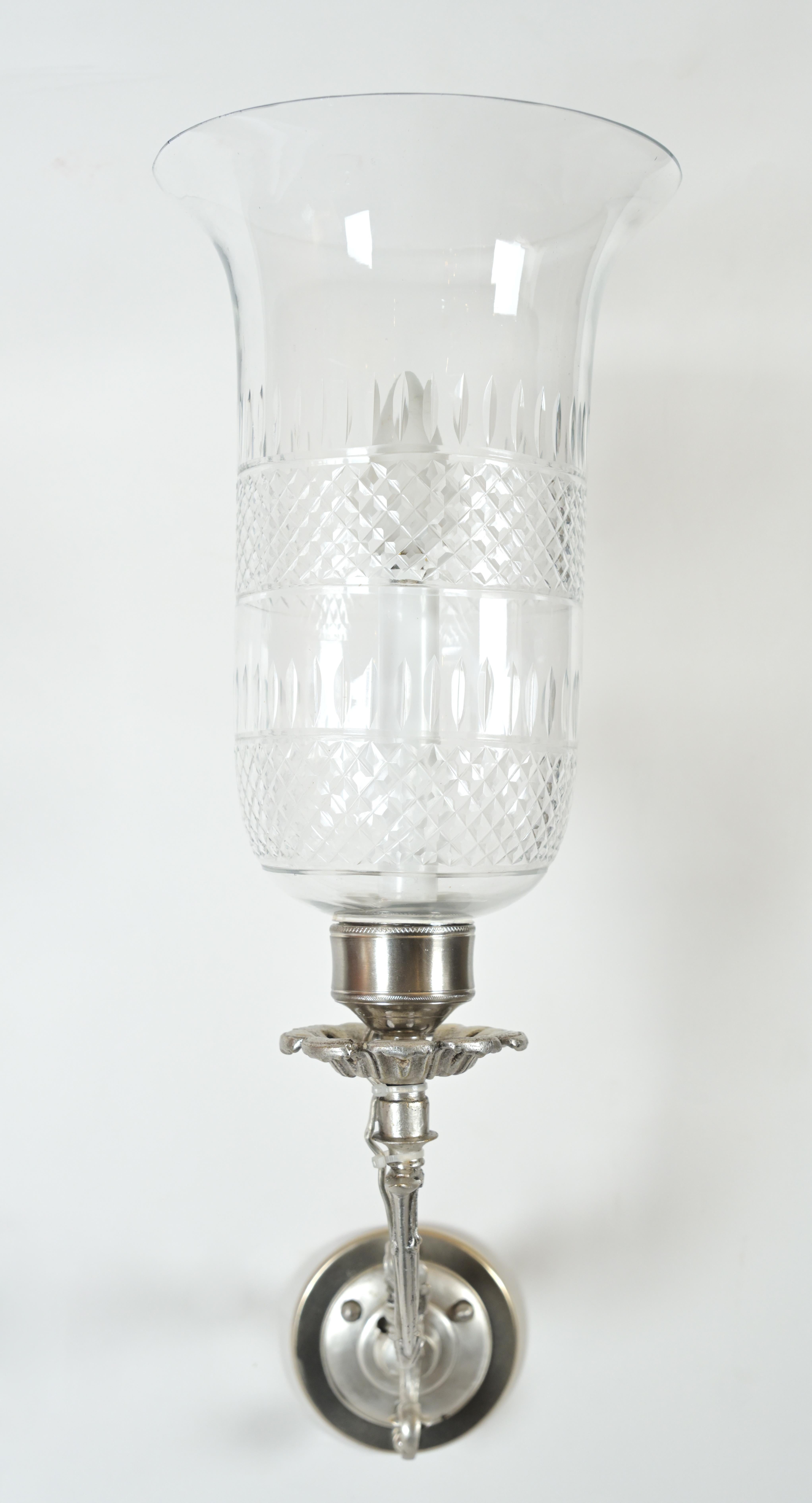 A pair of vintage sconces having floral decorated silver arms with a leaf bocchette cupping the light. The vase glass shades having two borders of cross hatched frames along the middle and bottom. Circa 1900s. UL wiring included.