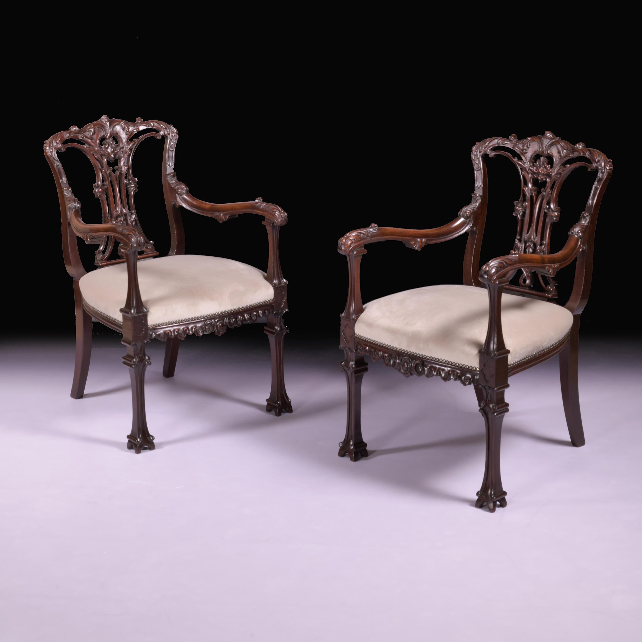 Ein schönes Paar Sessel aus dem 19. Jahrhundert im chinesischen Chippendale-Stil, mit gewölbtem Kamm über einer kunstvoll geschnitzten und verflochtenen Bandleiste, gepolstertem Sitz und geschwungenen Armlehnen, die Vorderbeine enden in