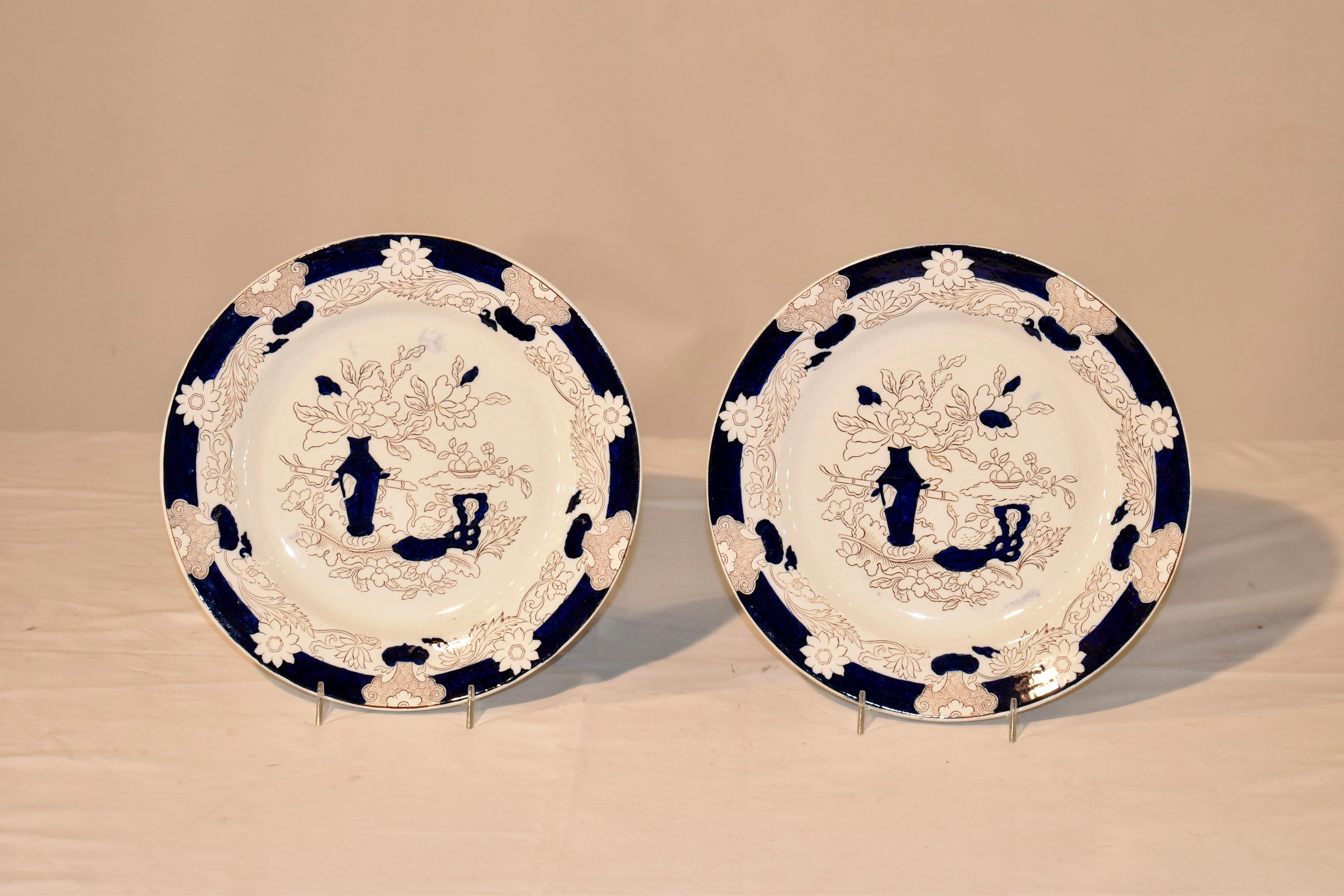 Pair of 19th century transfer plates with flow blue decoration. Marked with an impressed GL Ashworth mark. Ashworth pottery was in Hanley in Staffordshire. The plate is in a sepia colored transfer and the plates are hand colored in flow blue dark