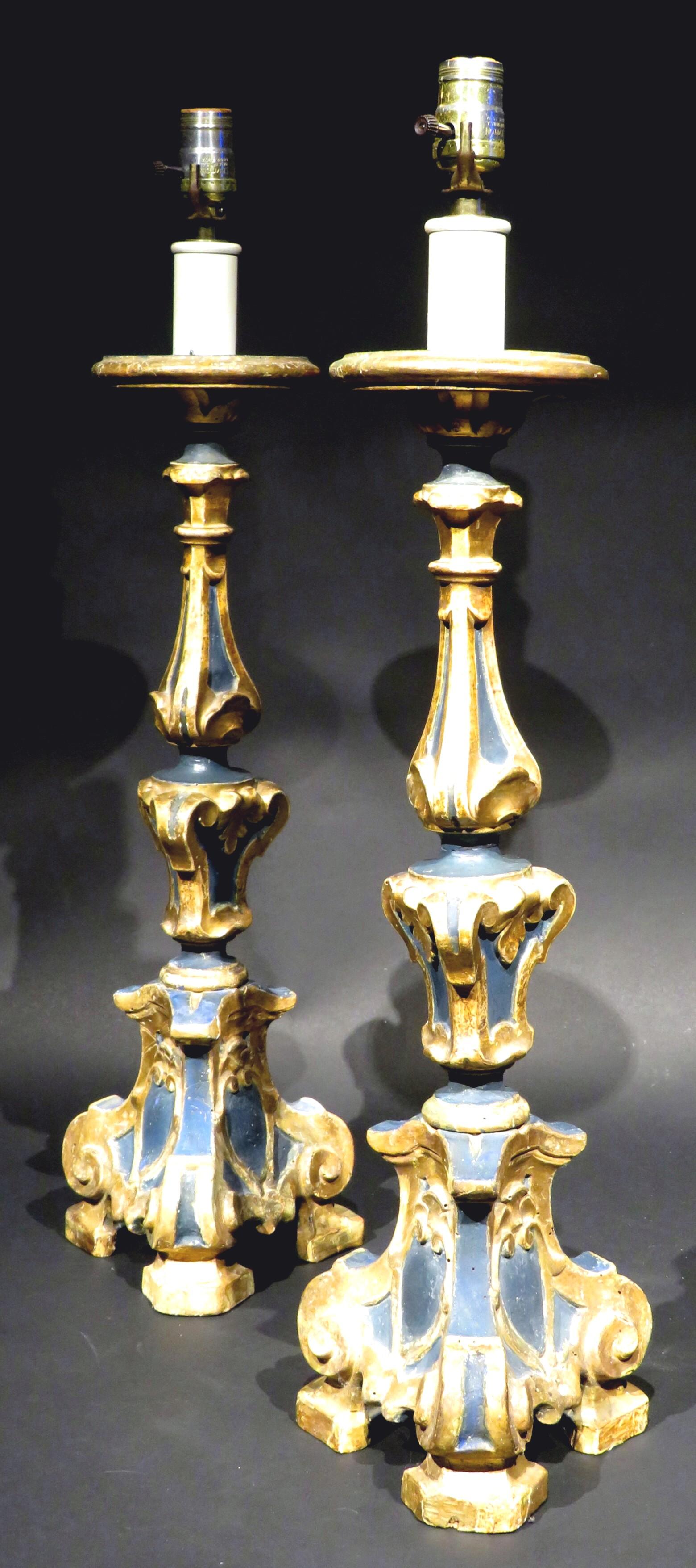 A highly decorative & robust pair of 19th century hand-carved & painted Italian Baroque style pricket / torchère table lamps, previously as candlesticks but having been converted to electricity decades ago. 
Both showing triangular columns with