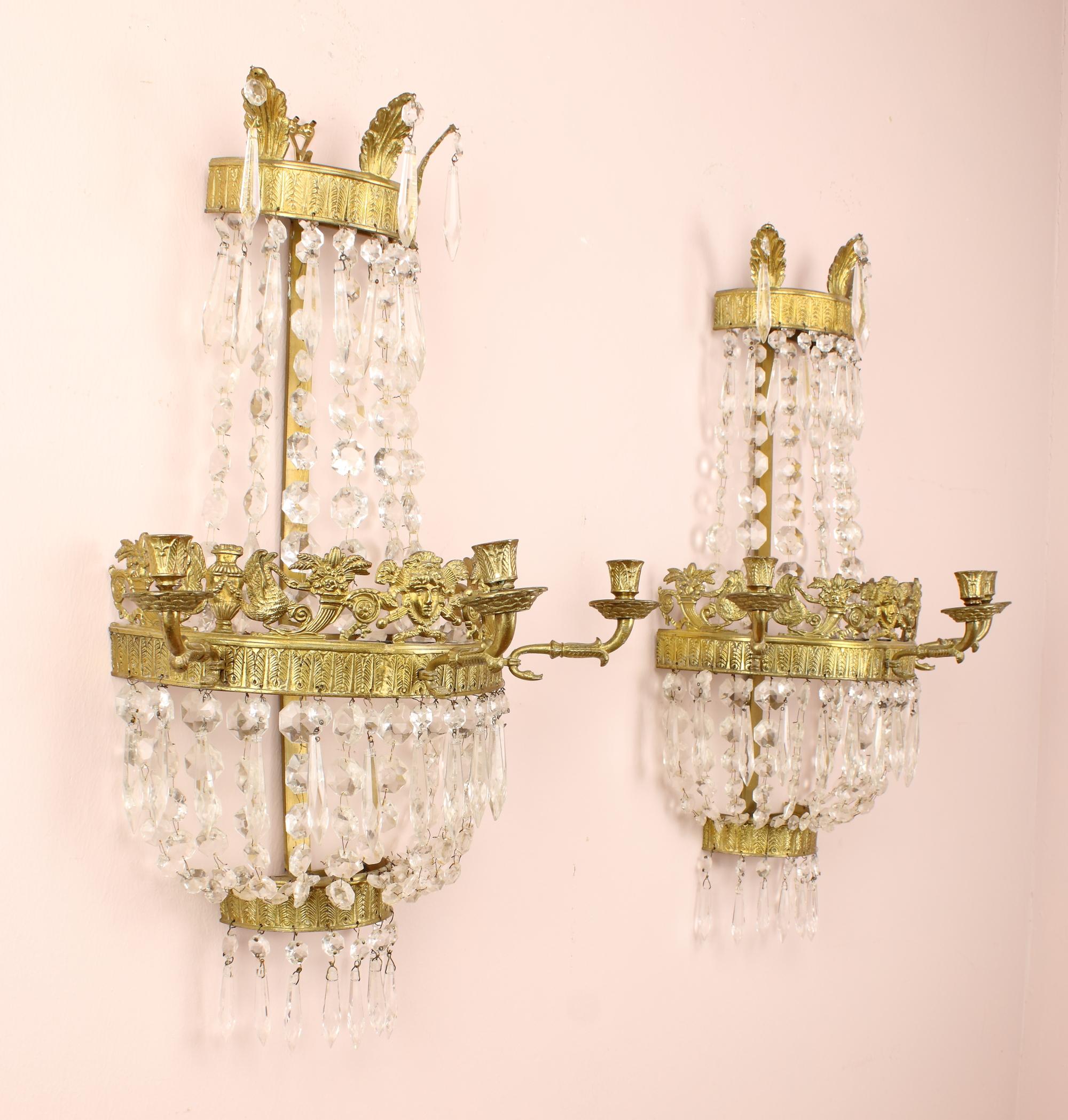 Pair of Early 19th century basket shape gilt bronze crystal empire wall lights.

Cross-shaped gilt-bronze backplate with three semicircular rings decorated with stylised feather friezes. The larger central ring, which is topped by an Apollons'