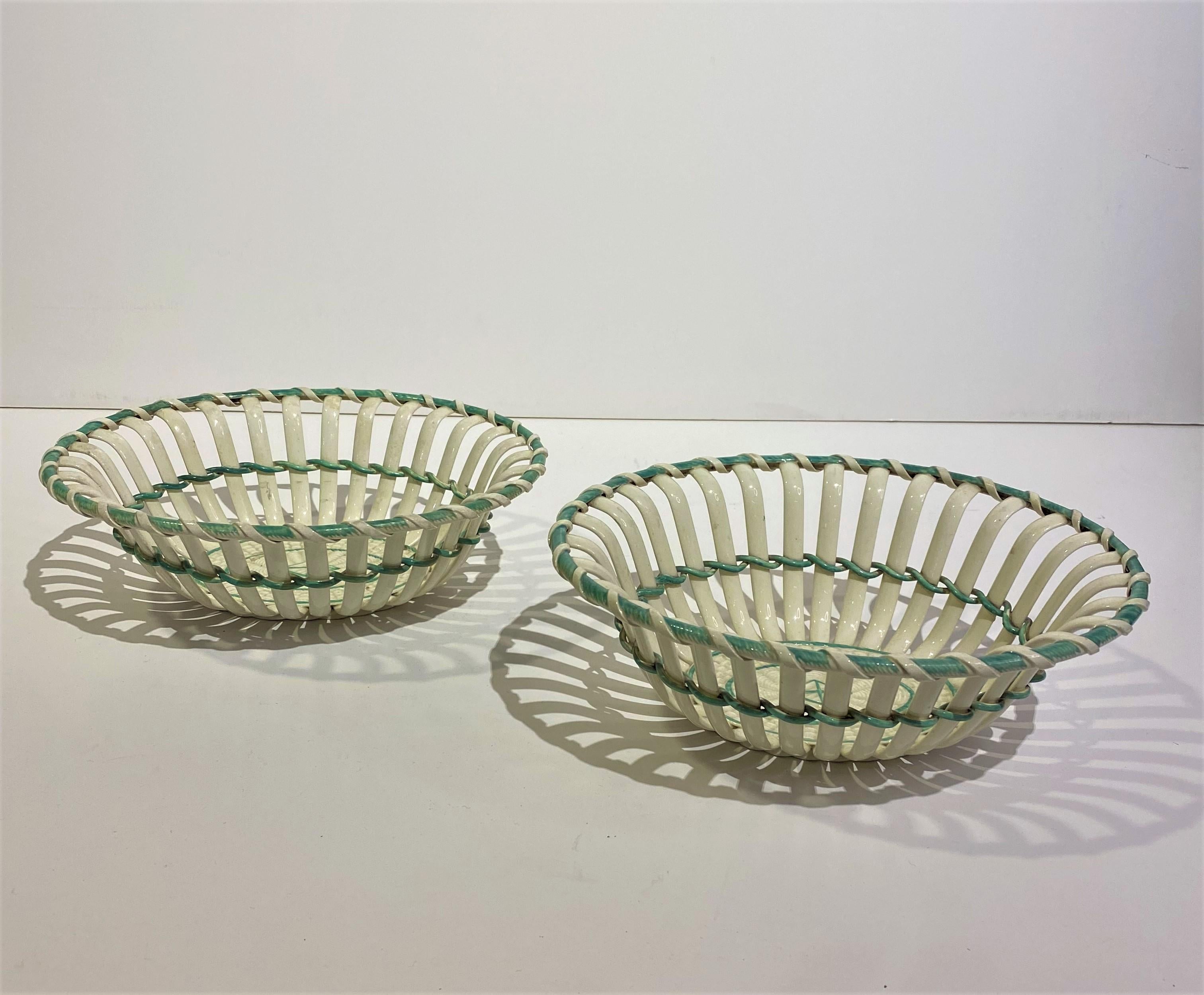 A fine pair of 19th-century creamware bi-color pierced baskets represents a pinnacle of ceramic craftsmanship during this period. Creamware, a type of refined earthenware, gained popularity in the 18th century and continued to be appreciated into