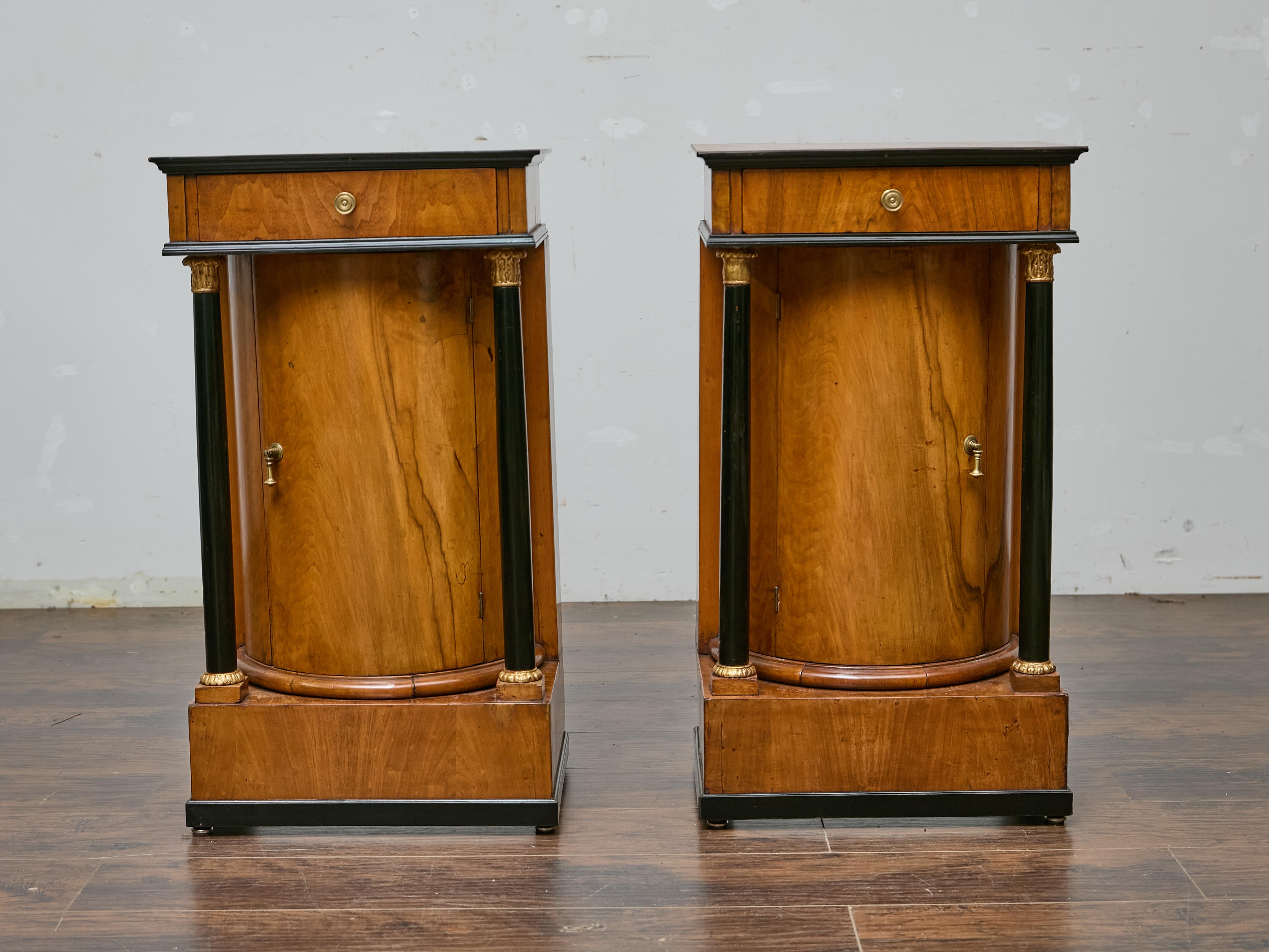 Cette exquise paire de cabinets autrichiens Biedermeier, probablement viennois et datant d'environ 1840, incarne l'élégance et la sobriété de l'époque. Fabriquées en noyer aux tons chauds, les armoires présentent d'étonnantes colonnes ébonisées avec